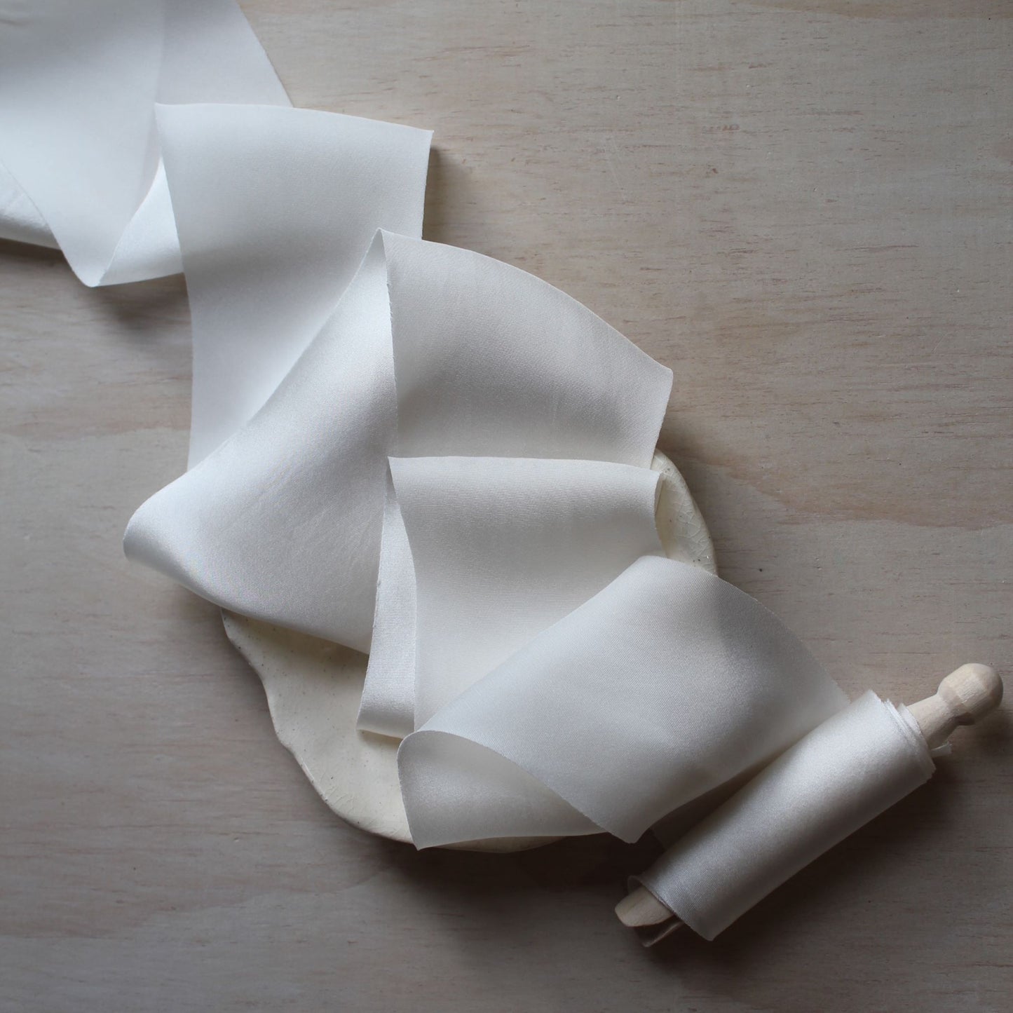 Close-up of the off white silk ribbon highlighting its smooth texture and subtle sheen