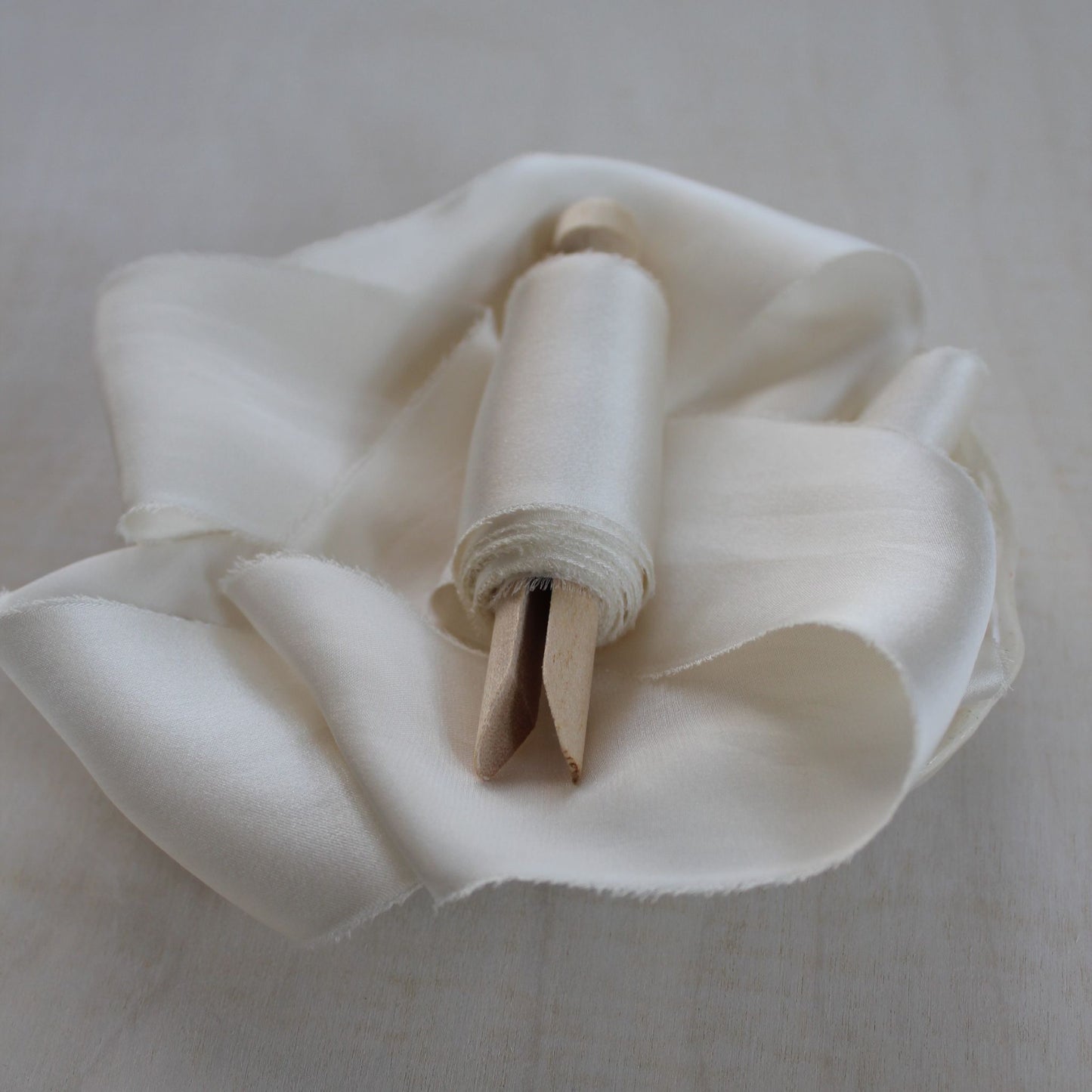 Naturally dyed off-white silk ribbon with soft sheen and matte underside
