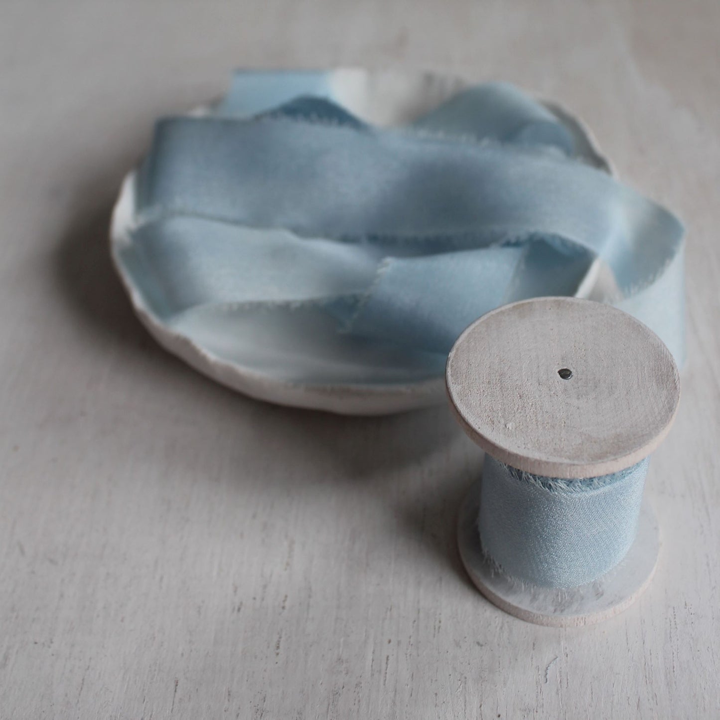 Naturally dyed silk ribbon in pale blue, torn by hand and loosely coiled