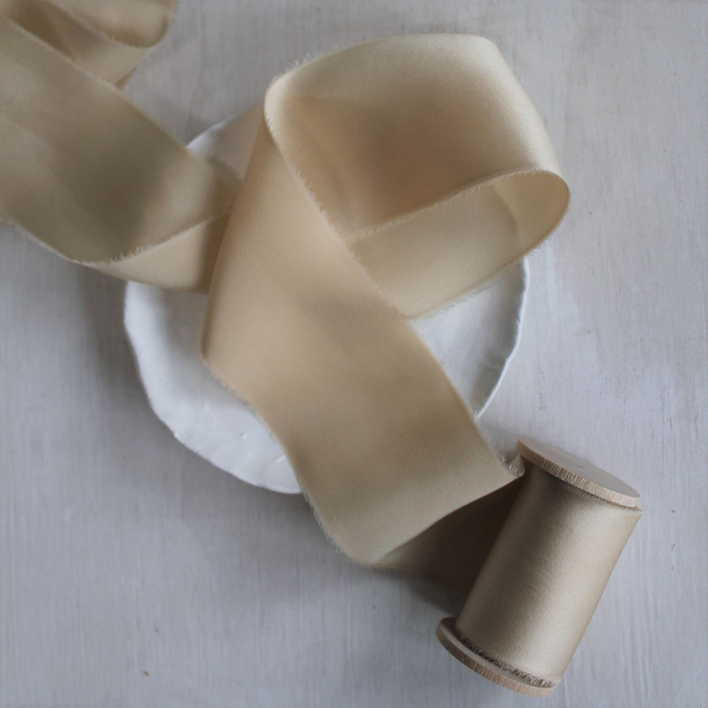 Maple silk charmeuse ribbon on wooden spool, ideal for styling bouquets, invitations, and wedding details.