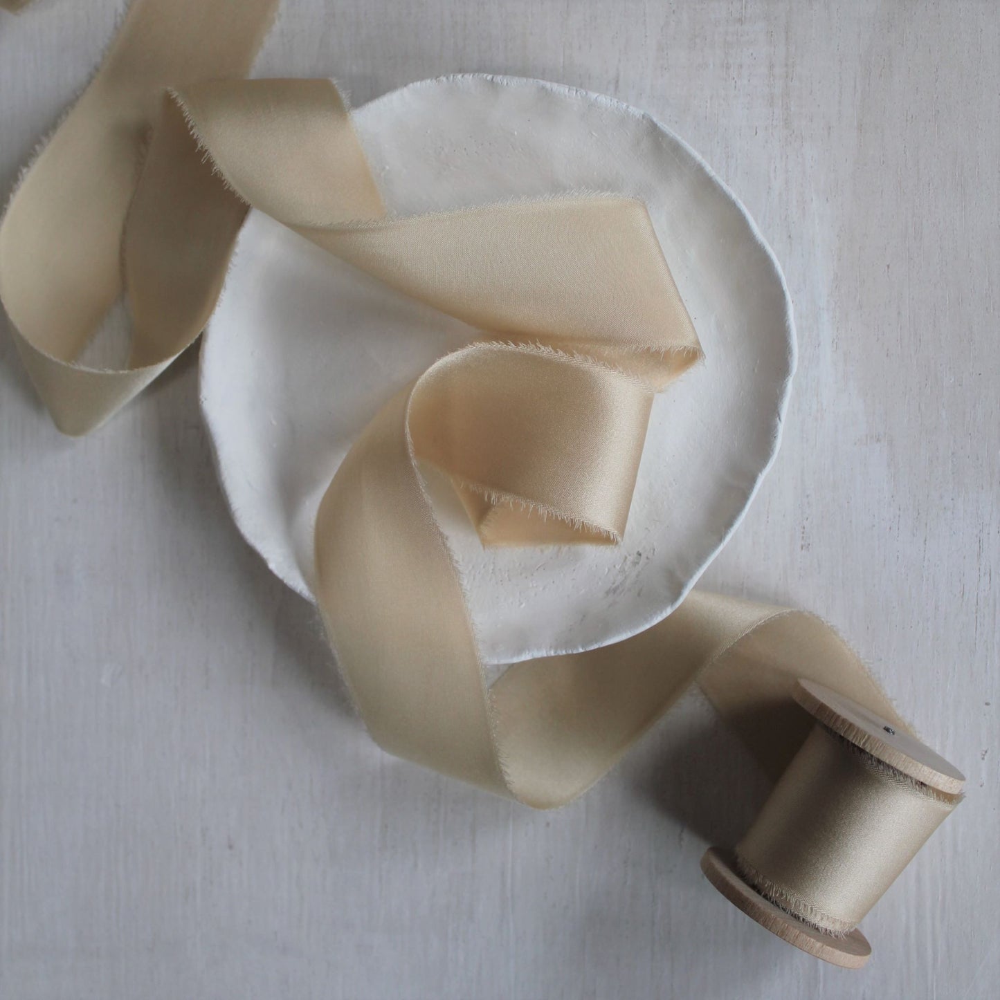 Luxurious maple silk charmeuse ribbon, naturally dyed and hand-torn, with a refined sheen.