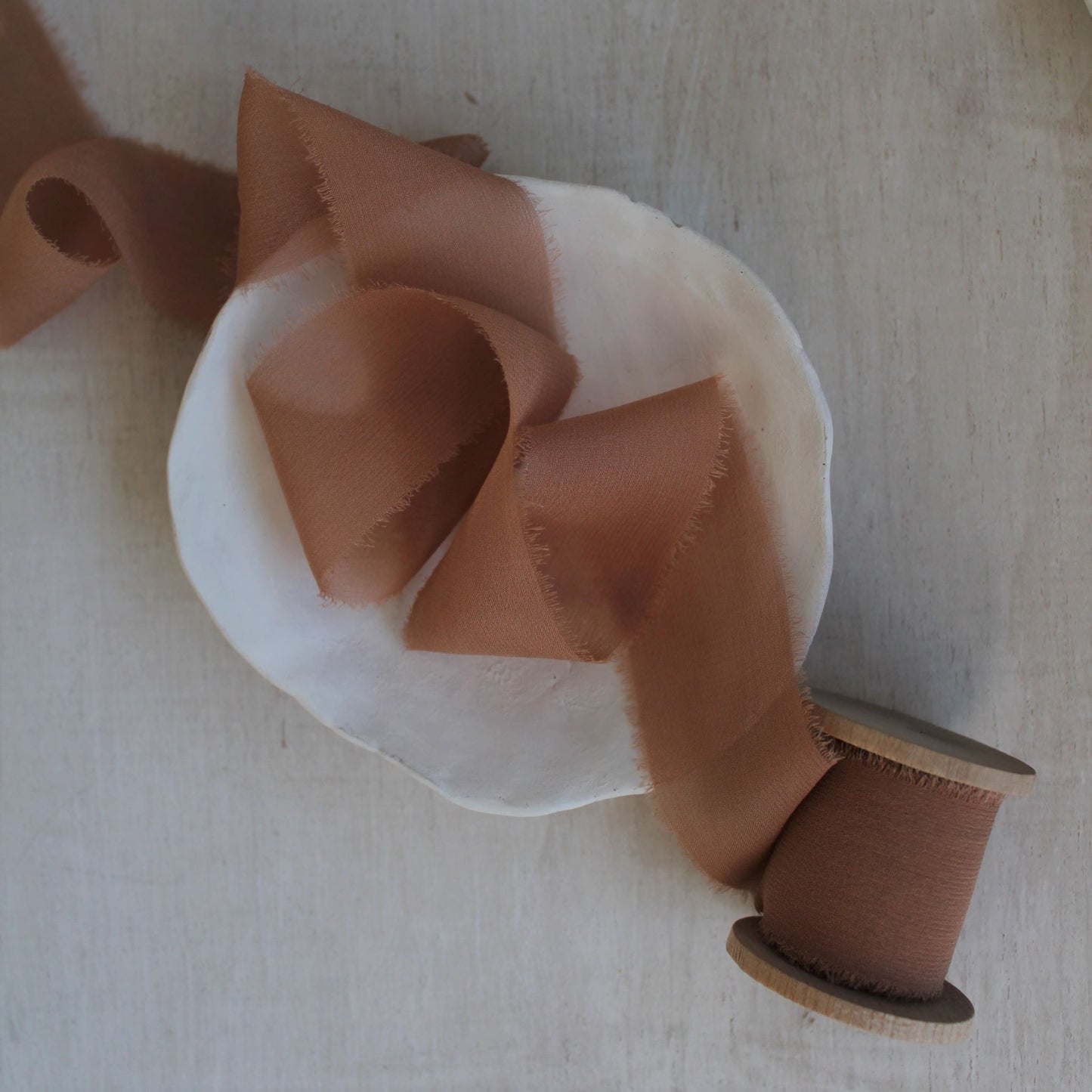 Hand-dyed terra cotta chiffon silk ribbon draped in soft folds