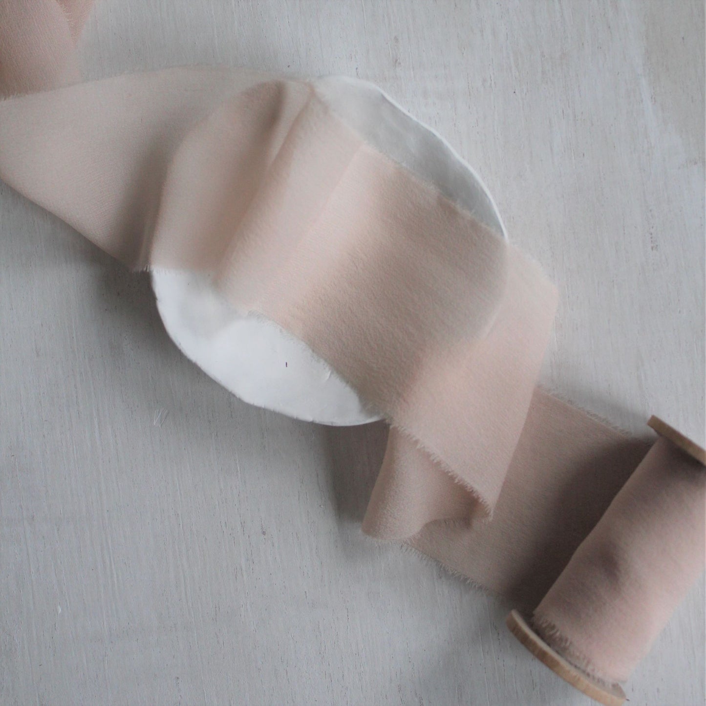 Touch of Pink ribbon with a soft, feathery finish, photographed alongside natural materials to reflect its handmade quality
