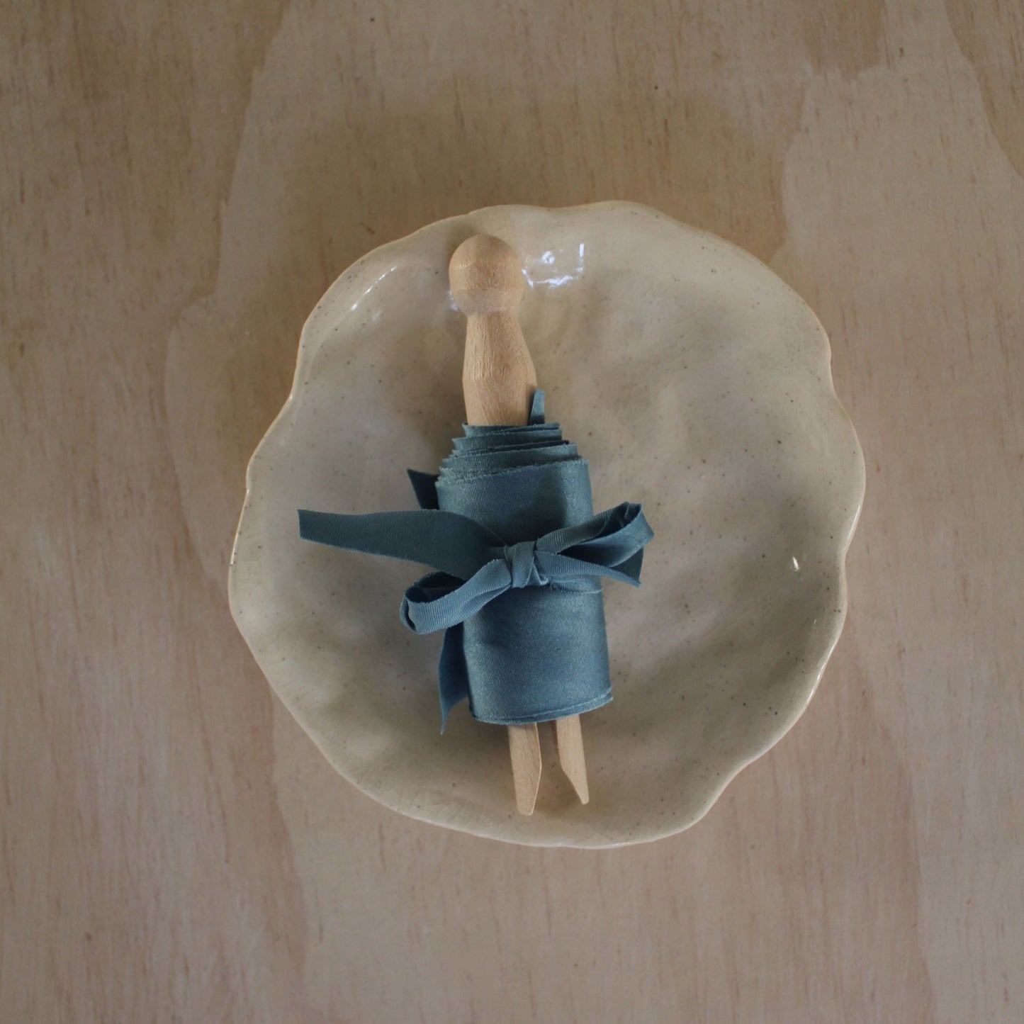 Luxury blue silk ribbon bias cut, handmade in Canada, displayed on a ceramic plate, perfect for weddings and stationery.