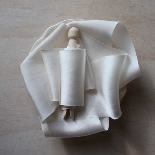Off white silk charmeuse ribbon, hand-cut on the bias, displayed in soft folds to showcase its elegant drape