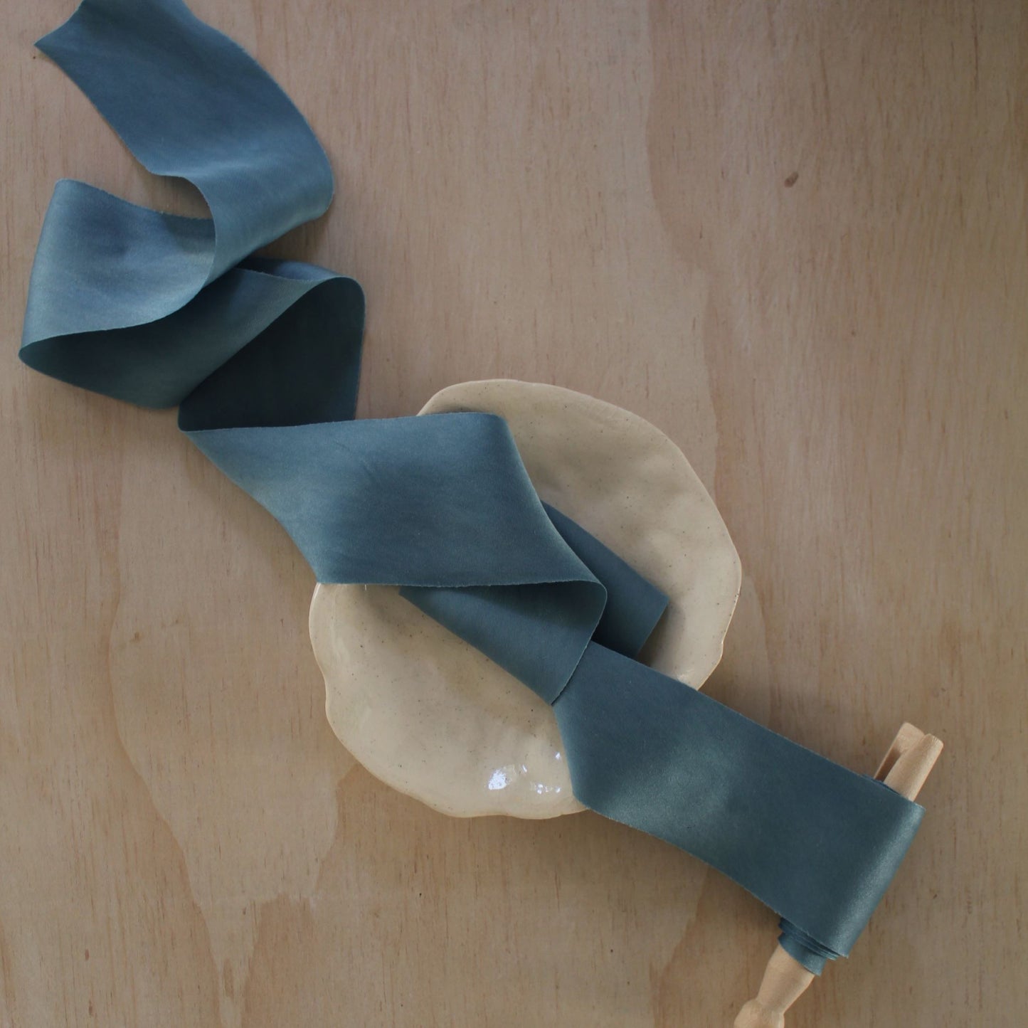 Handmade blue silk charmeuse ribbon bias cut, naturally dyed with indigo, perfect for weddings and stationery.
