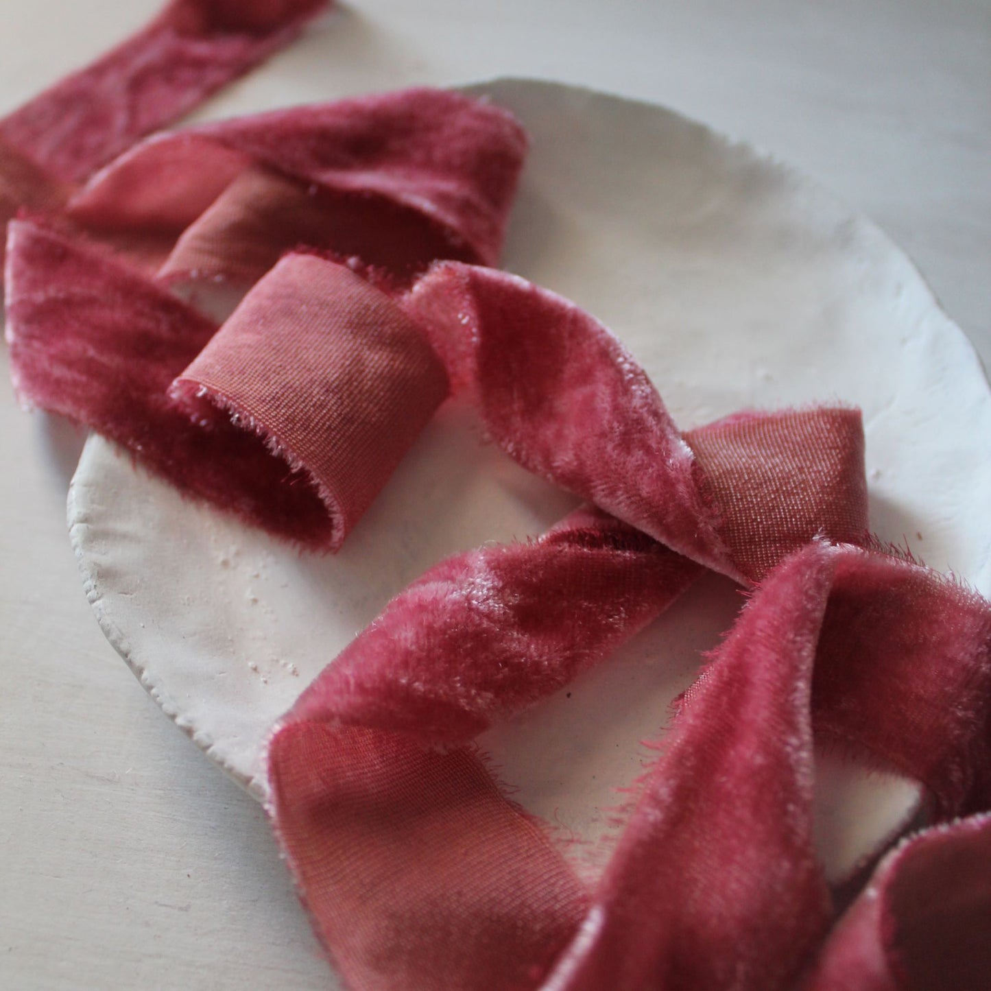 Close-up of hand-torn edge on magenta silk velvet ribbon