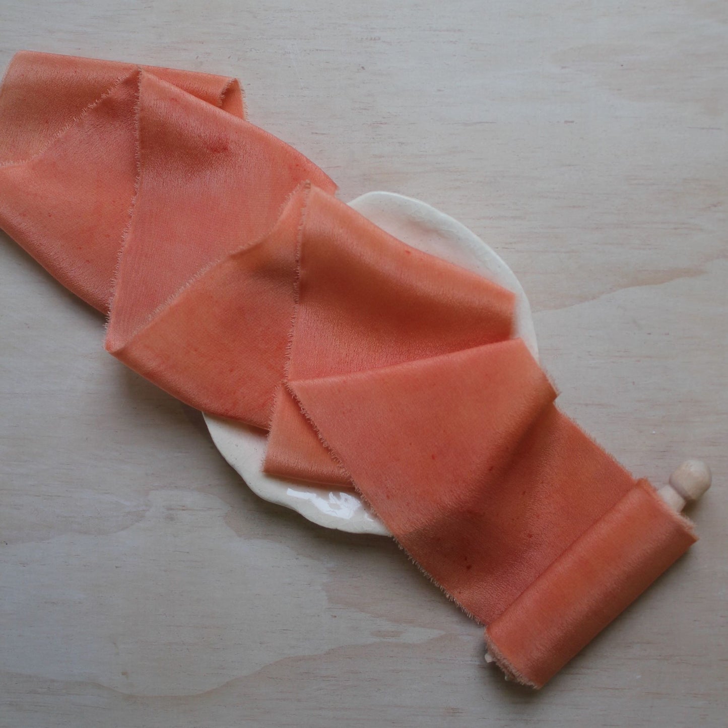 Coral peach silk crepe de chine ribbon hand-torn with soft edges, ideal for creating elegant wedding bouquets.