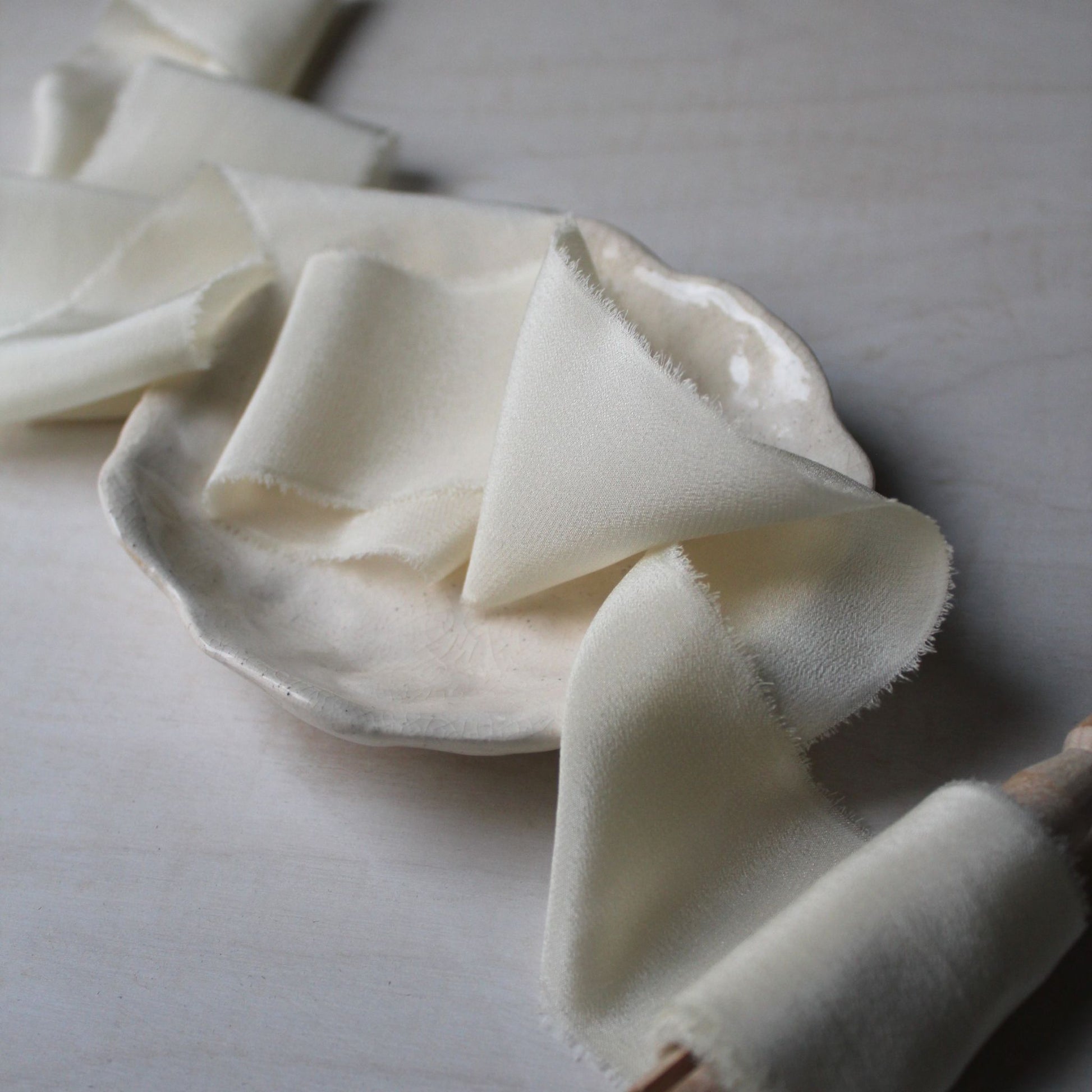 Soft off-white silk ribbon made by a Canadian small business, ideal for wrapping wedding invitations or bouquets.