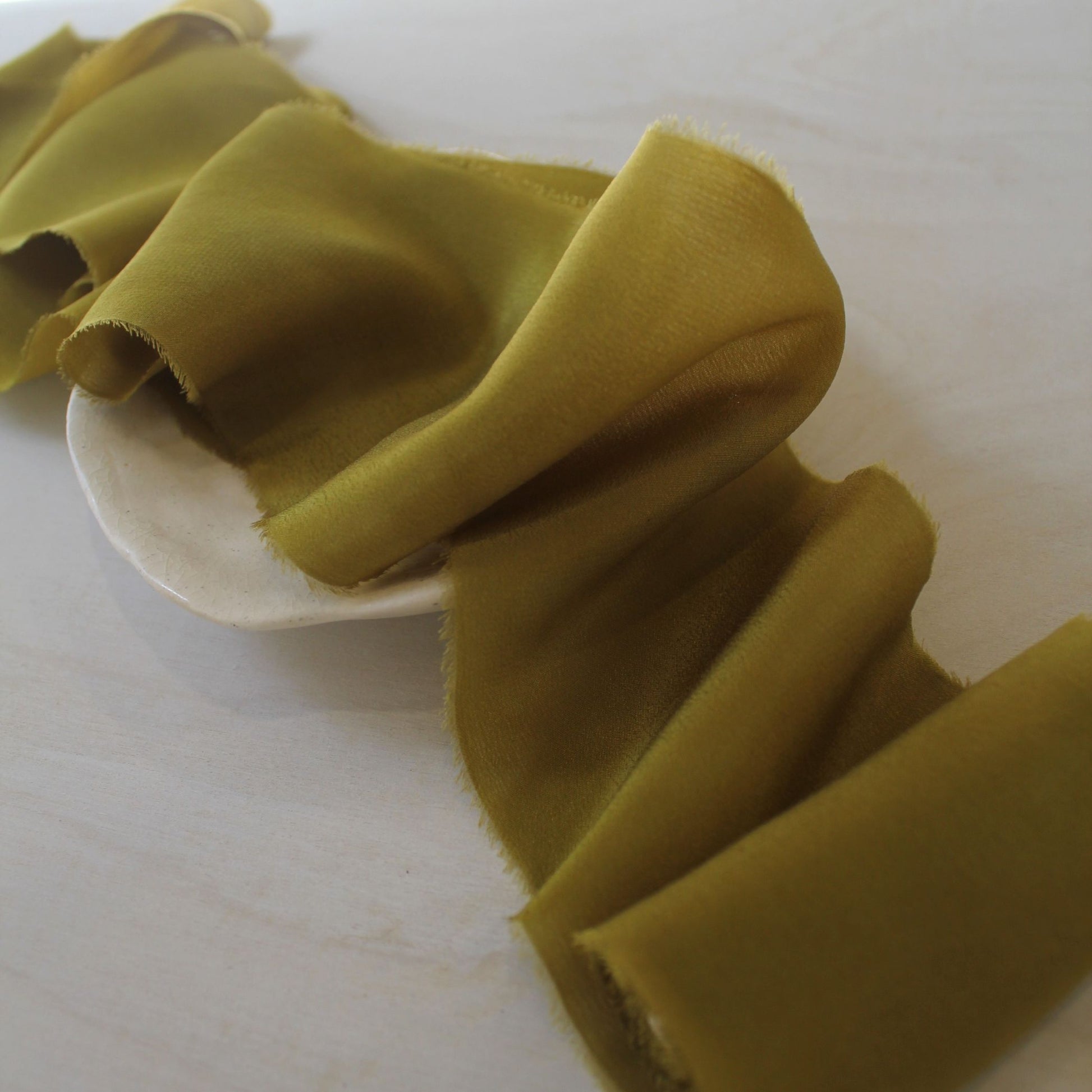 Close-up of dark chartreuse silk ribbon for wedding decor