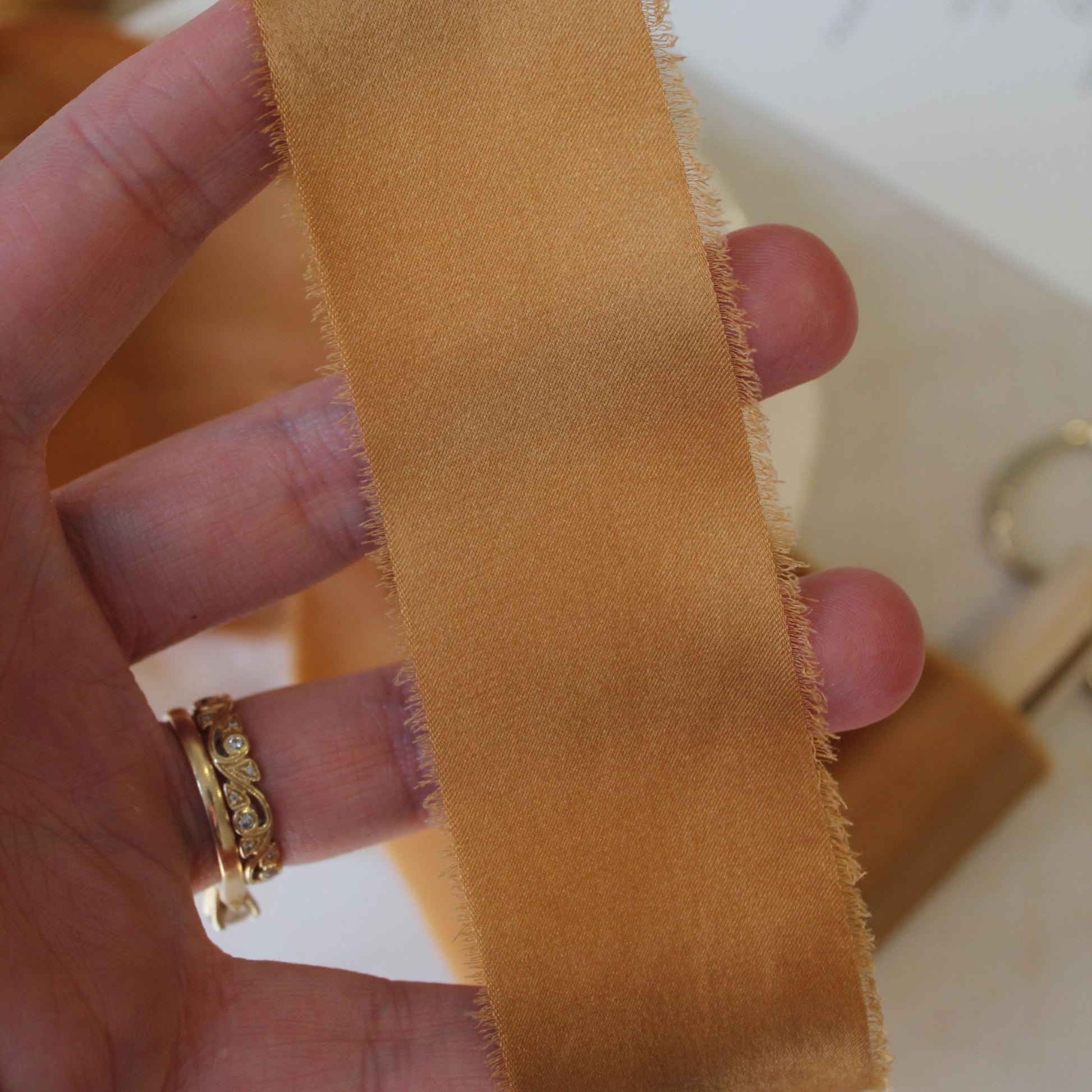 Hand torn terra cotta charmeuse silk ribbon, perfect for weddings and floral design, showcasing its natural dye and texture.