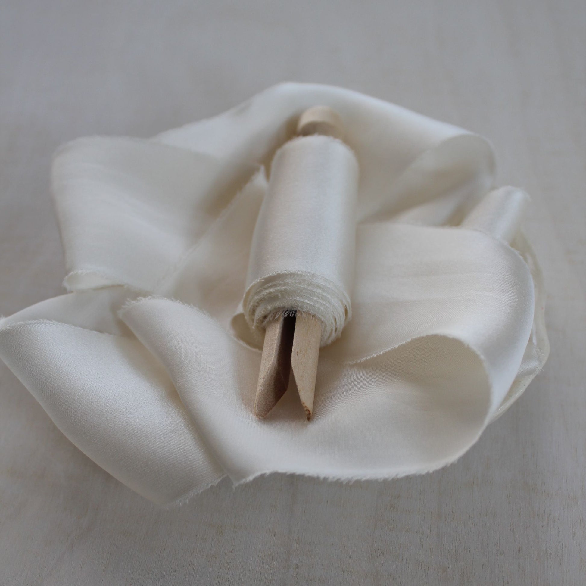 Naturally dyed off-white silk ribbon with soft sheen and matte underside


