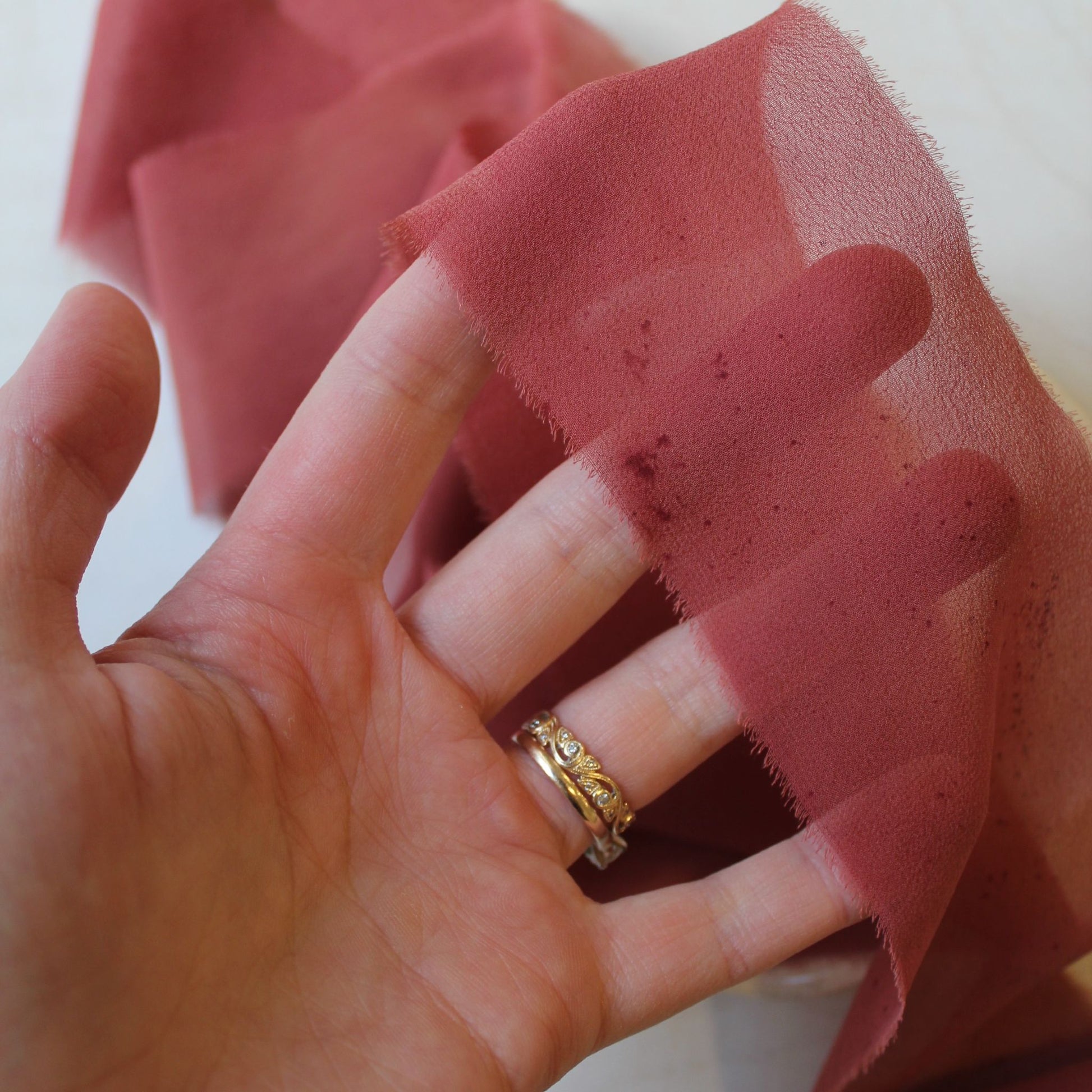 Red rust chiffon silk ribbon used in bridal styling and wedding photography.