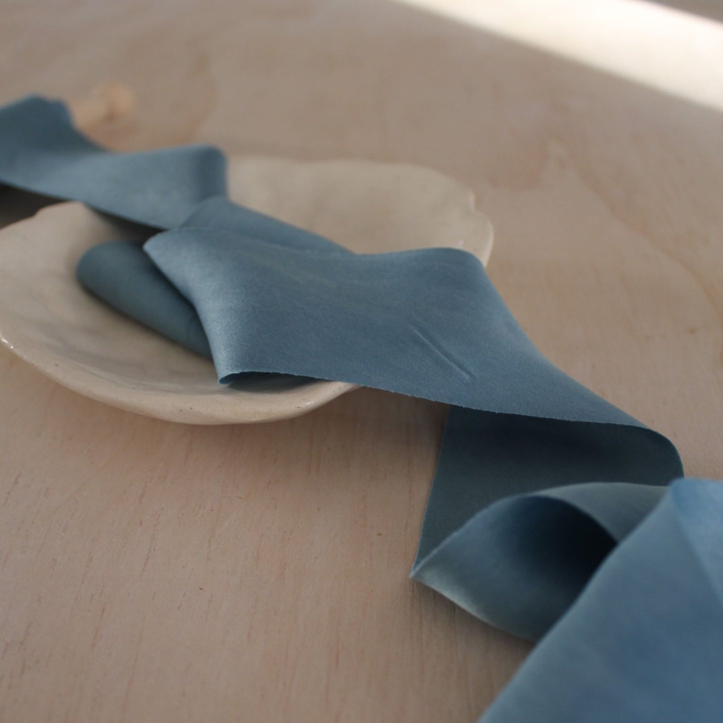 Handmade blue silk charmeuse ribbon bias cut, naturally dyed with indigo, perfect for luxury weddings and stationery.