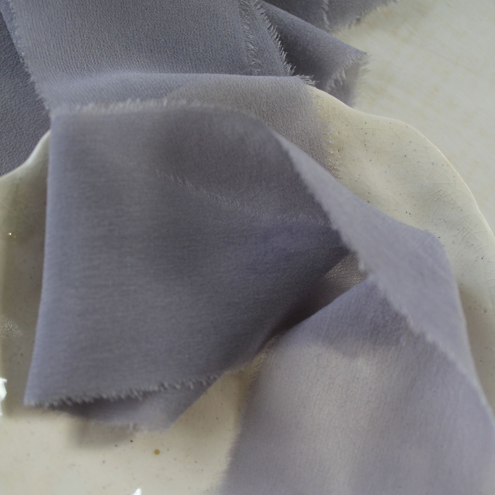 Close-up of mauve-lilac silk chiffon ribbon showcasing its sheer texture.