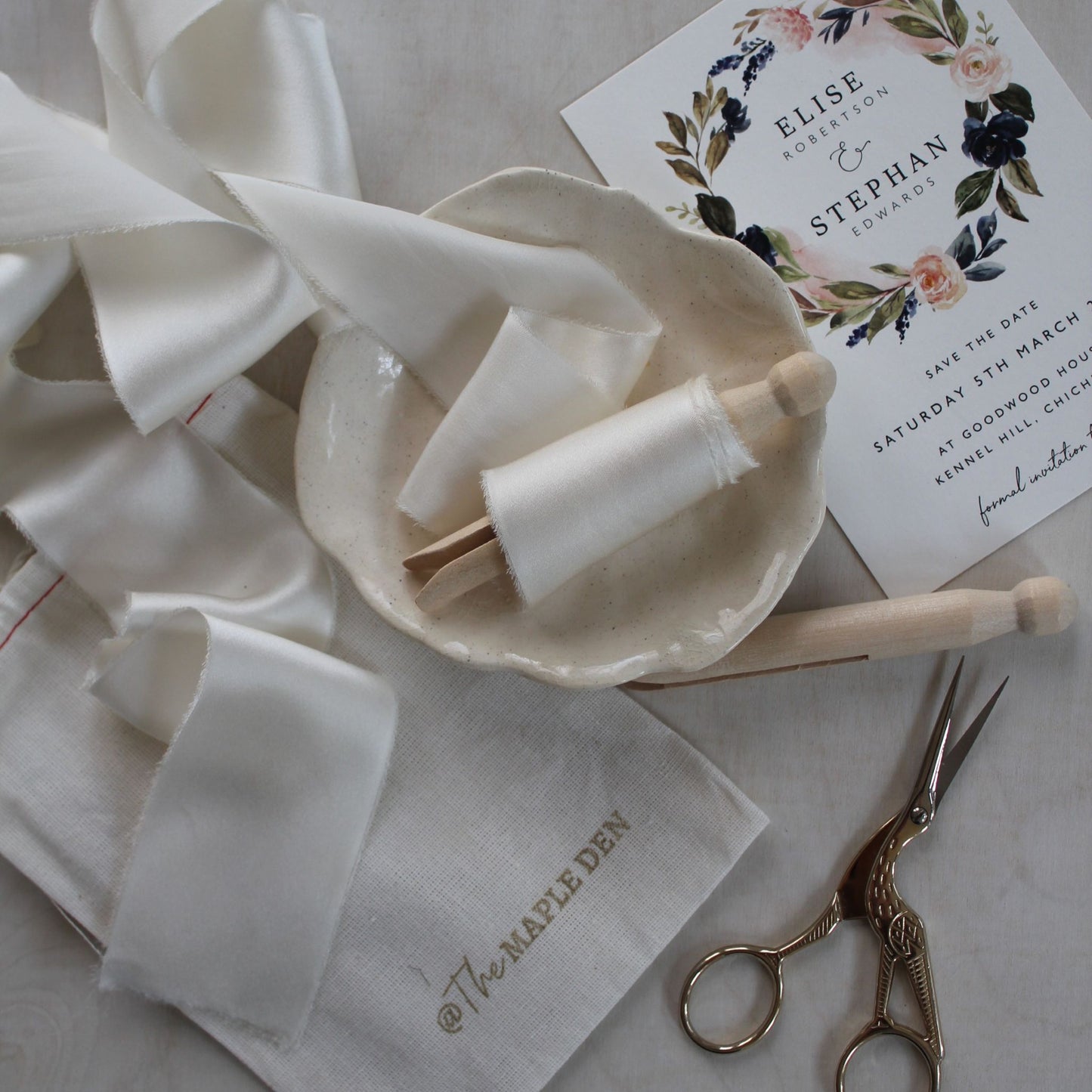 Hand-torn off-white charmeuse silk ribbon styled on wedding stationery