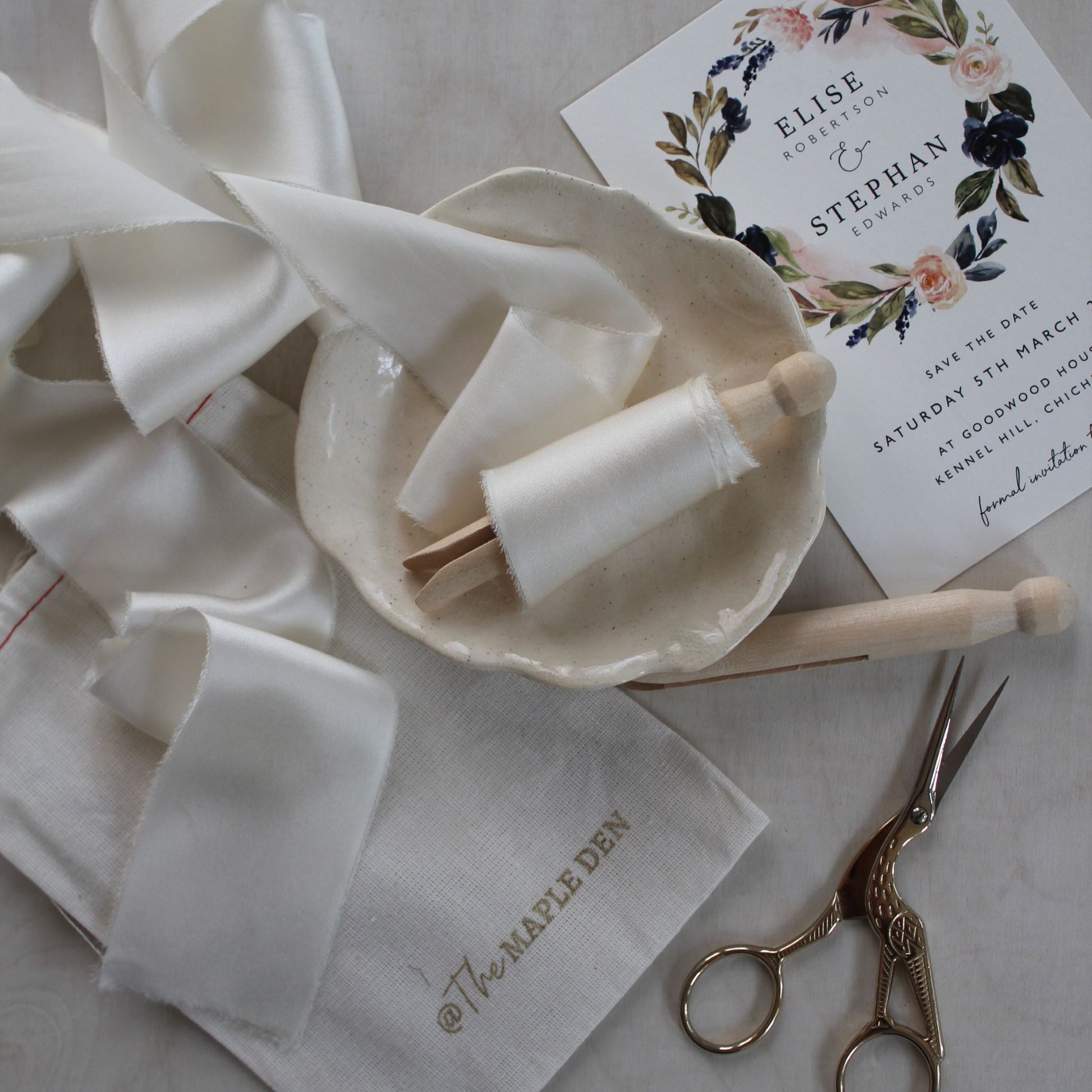 Hand-torn off-white charmeuse silk ribbon styled on wedding stationery