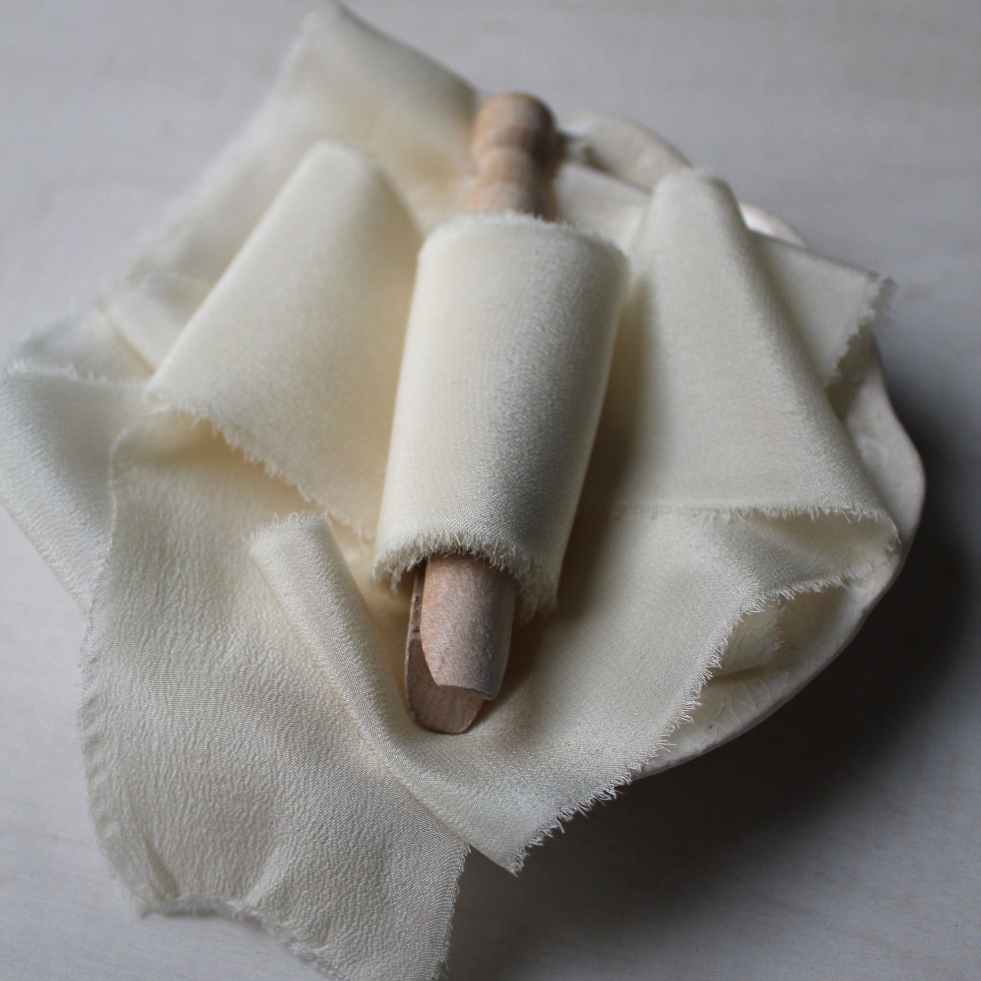 Off-white wedding ribbon made from crepe de chine silk, hand-torn with frayed edges, ideal for refined Canadian weddings.