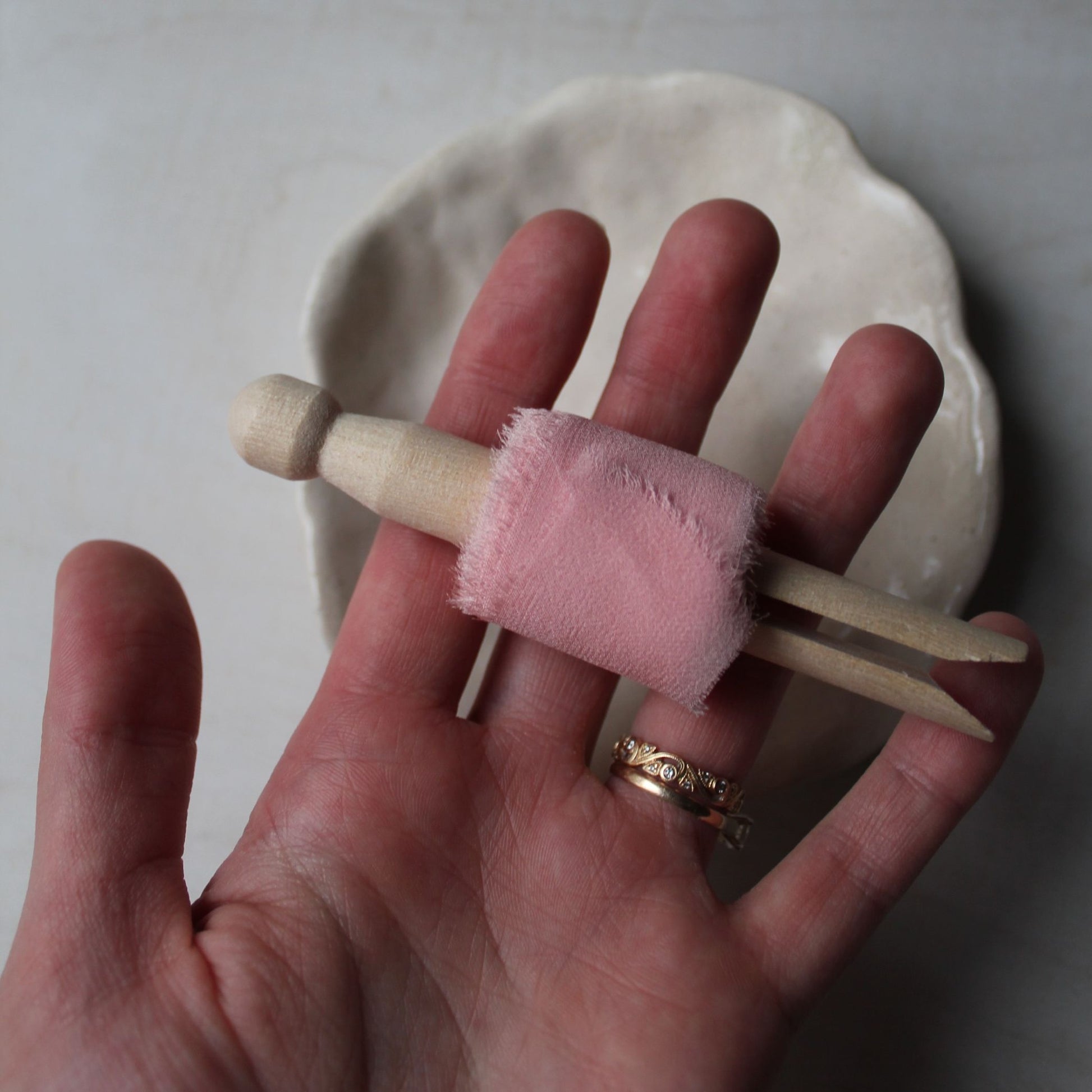 pink ribbon on a wood clothes peg in a hand