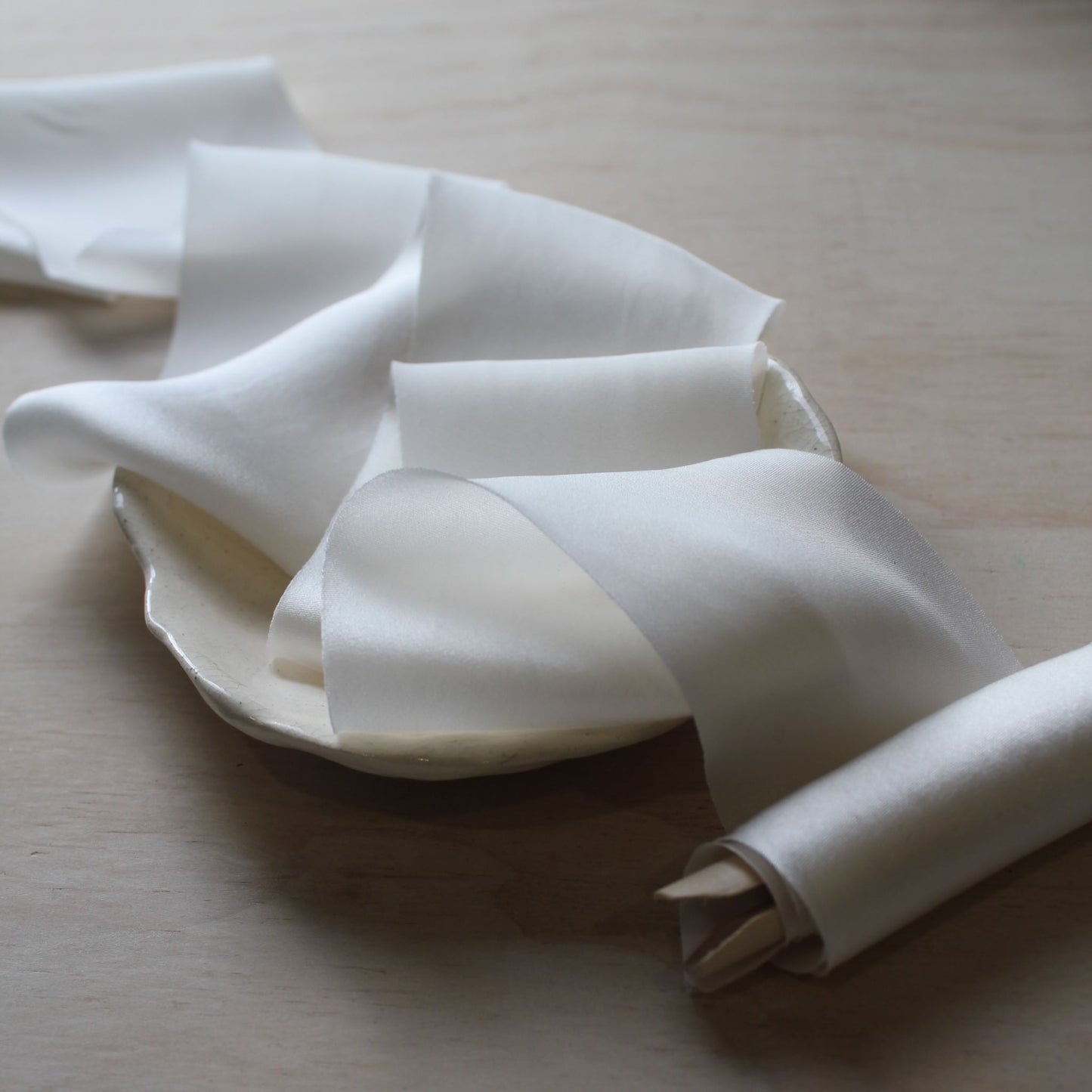 Elegant off white ribbon on natural wood background on a wood clothes peg
