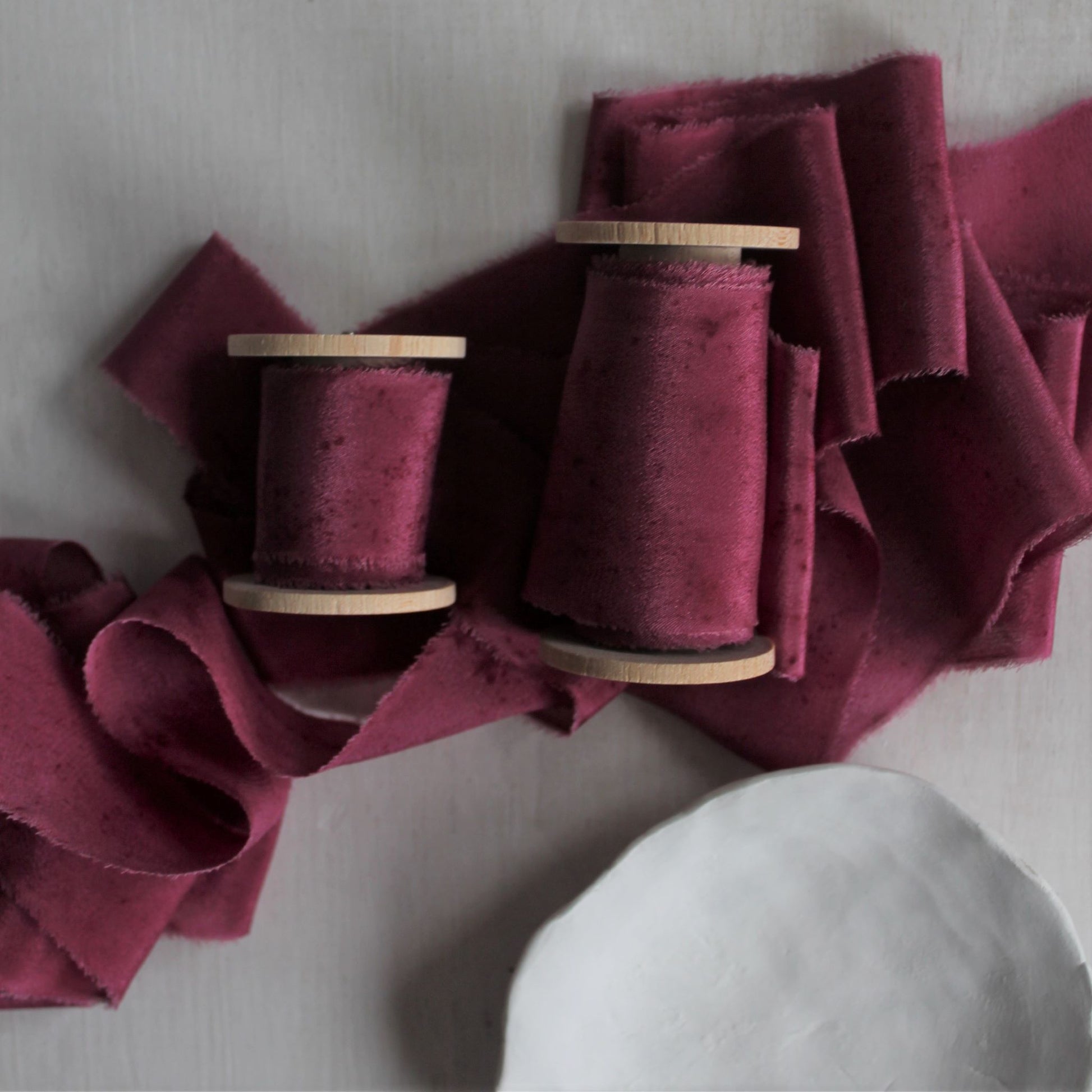 Berry silk ribbon used in wedding stationery, offering a luxurious touch for invitations and envelopes.