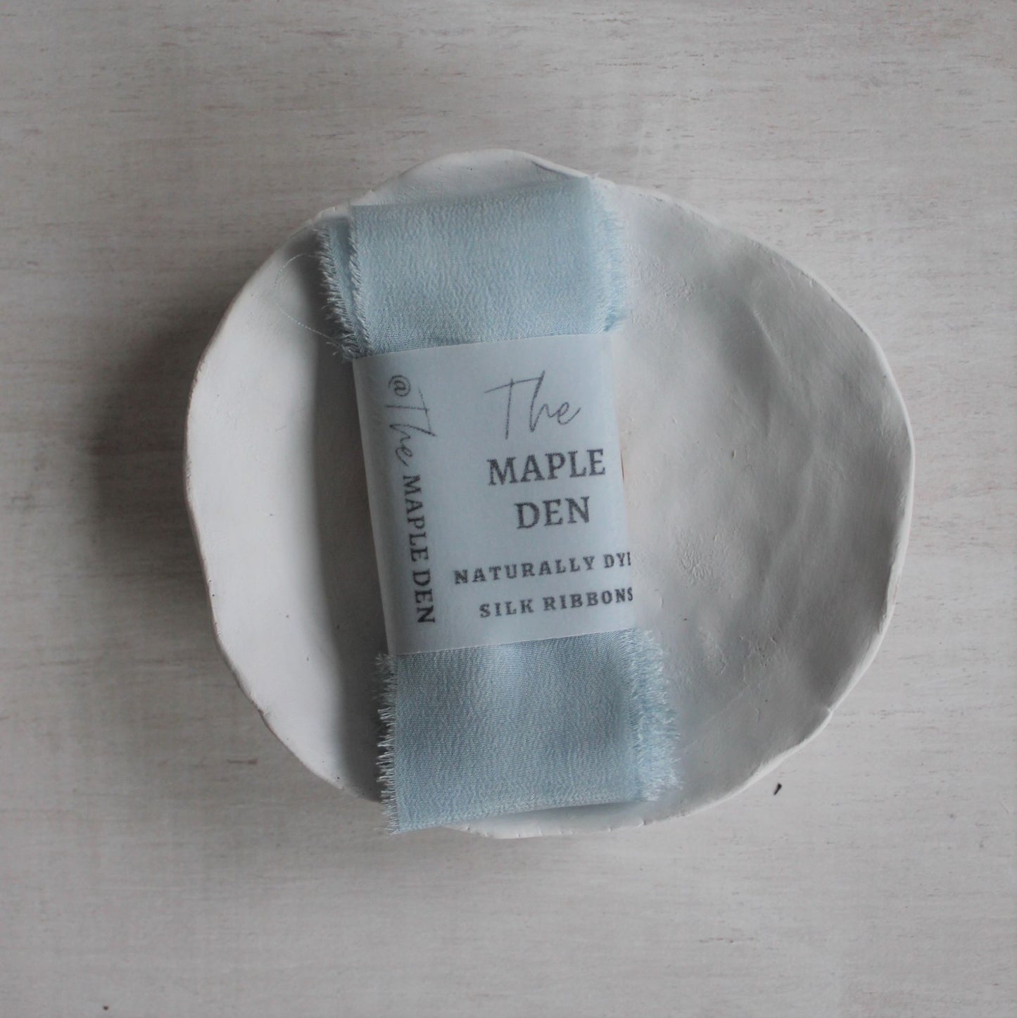Hand-dyed silk ribbon in light indigo blue for weddings or crafts folded with label