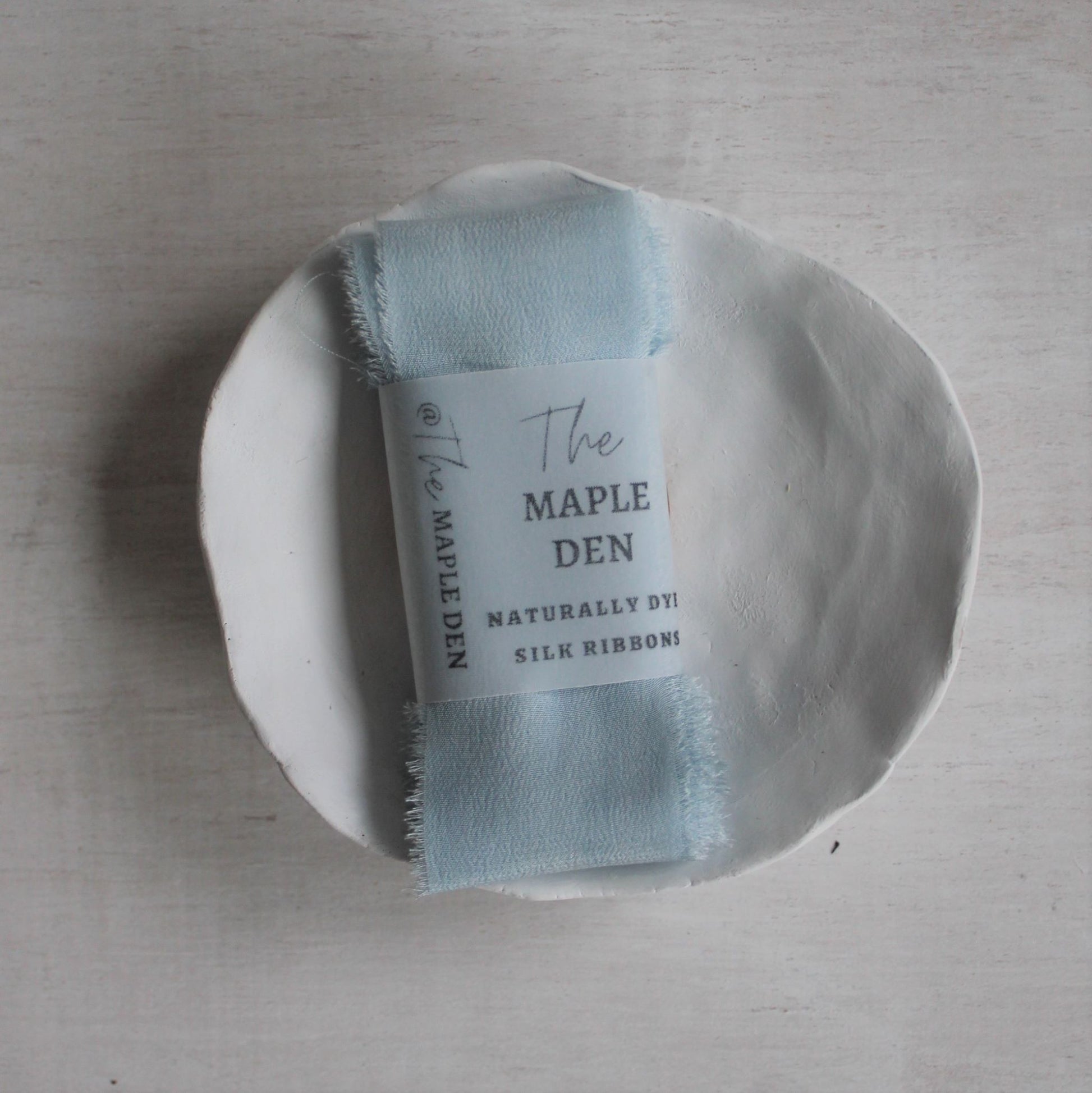 Hand-dyed silk ribbon in light indigo blue for weddings or crafts folded with label