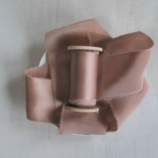 Dusty rose silk charmeuse hand-torn ribbon on wooden spool.