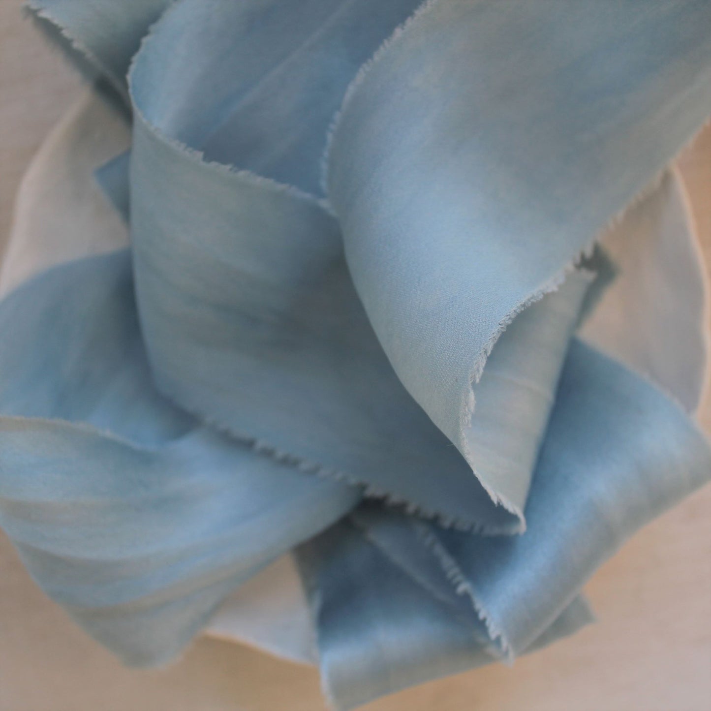 Close-up of pale blue silk ribbon highlighting subtle variations in tone and smooth texture