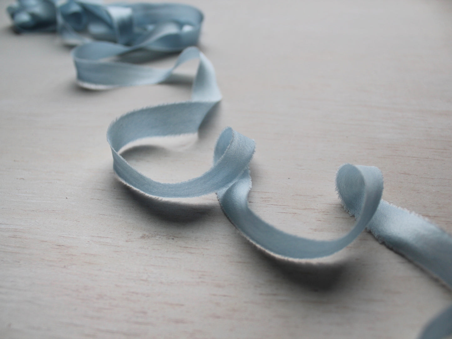 Narrow pale blue silk charmeuse ribbon, hand-cut on the bias, with a soft, flowing drape