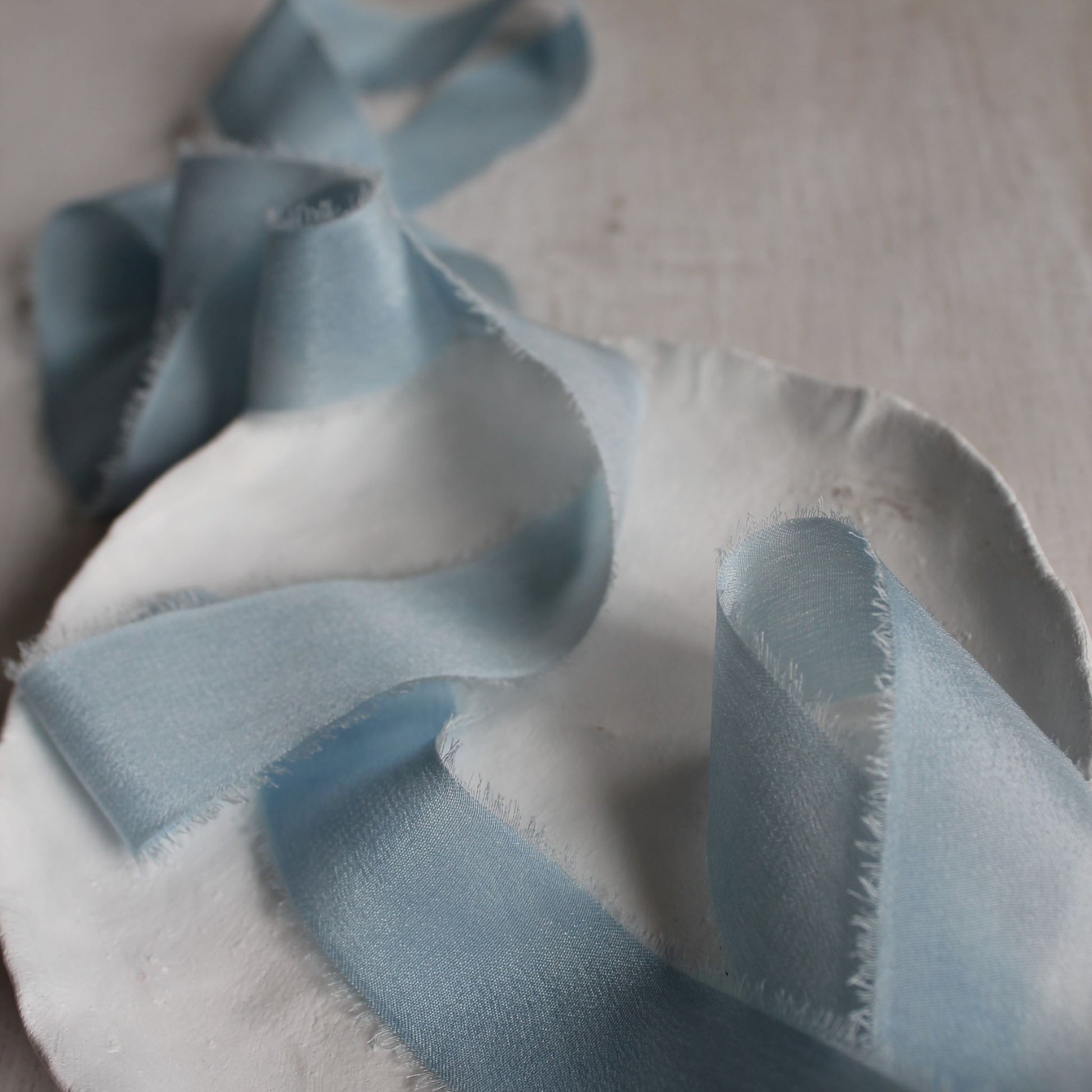 Light blue crepe de chine silk ribbon styled for wedding stationery