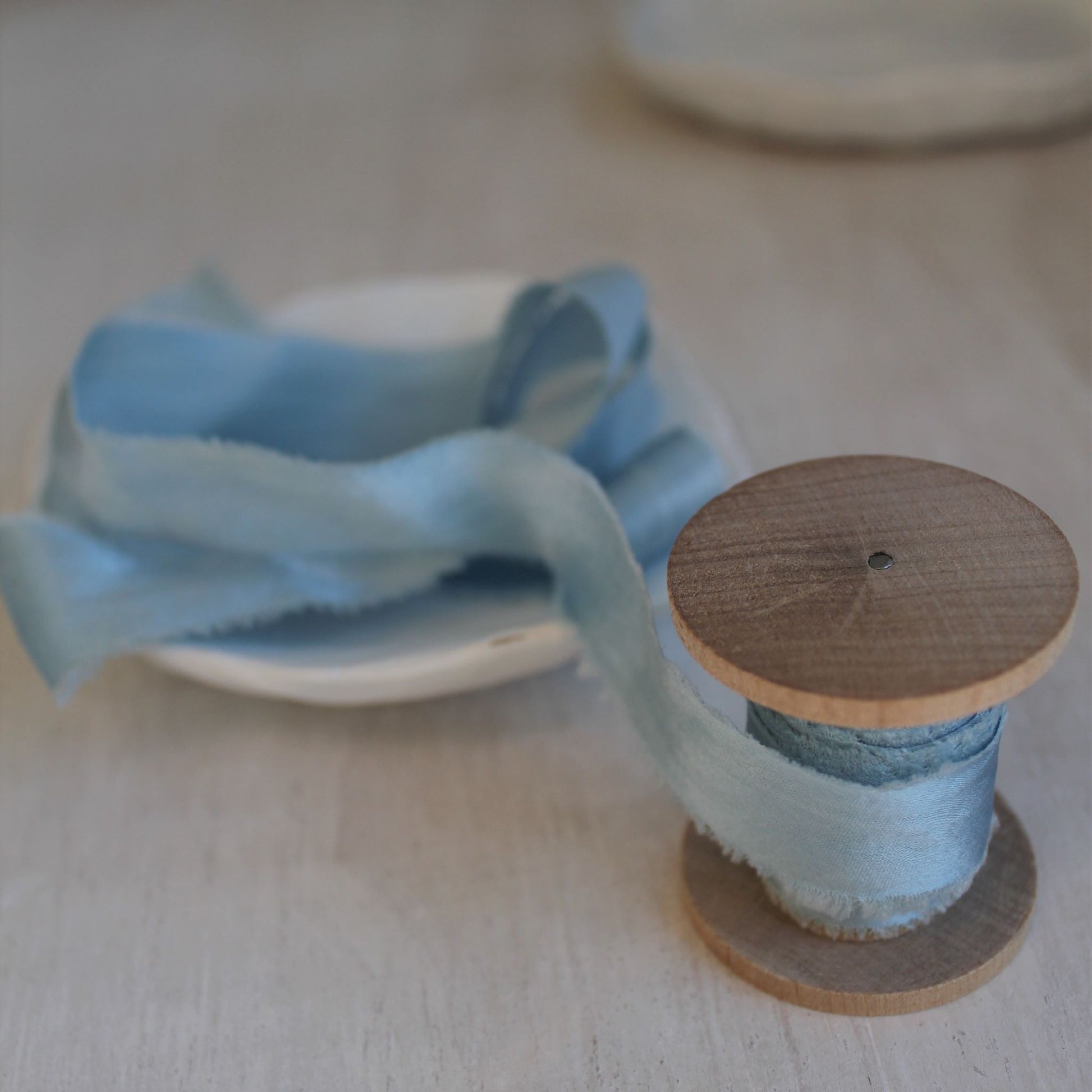 Handmade narrow silk ribbon in pale blue, naturally dyed and ideal for elegant touches