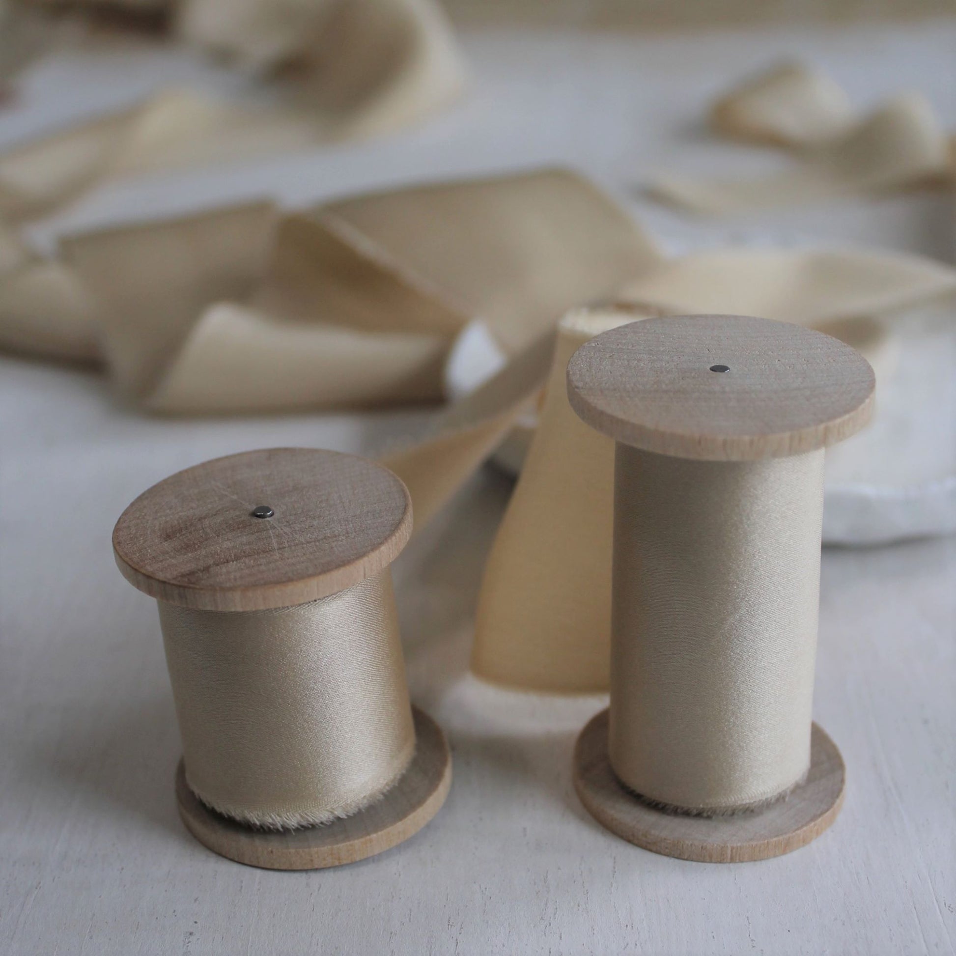 Naturally dyed maple silk charmeuse ribbon, hand-torn for a soft and feathered finish on wood spools