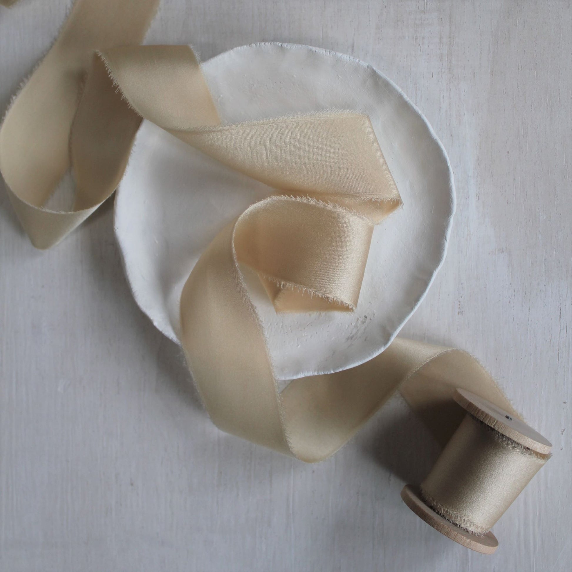 Luxurious maple silk charmeuse ribbon, naturally dyed and hand-torn, with a refined sheen.
