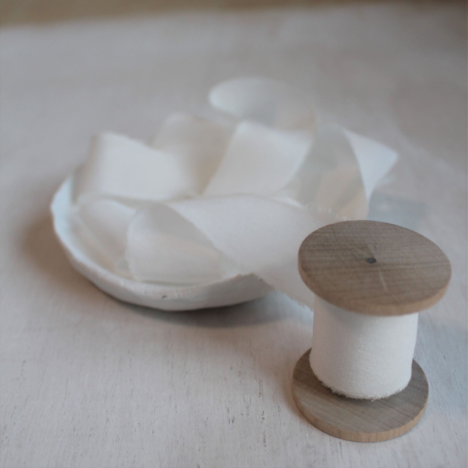 One-inch crepe de chine ribbon on a rustic wood spool