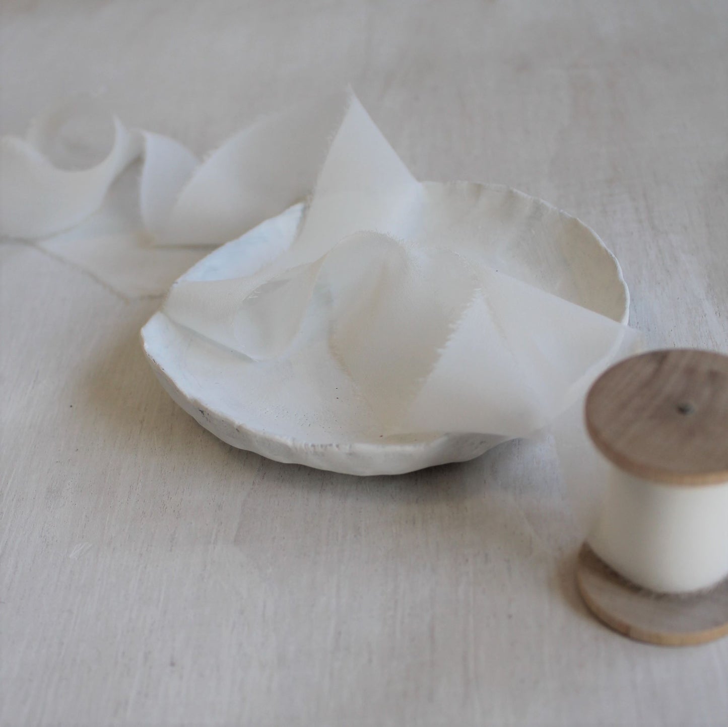 Lightweight chiffon ribbon rolled on a wooden spool