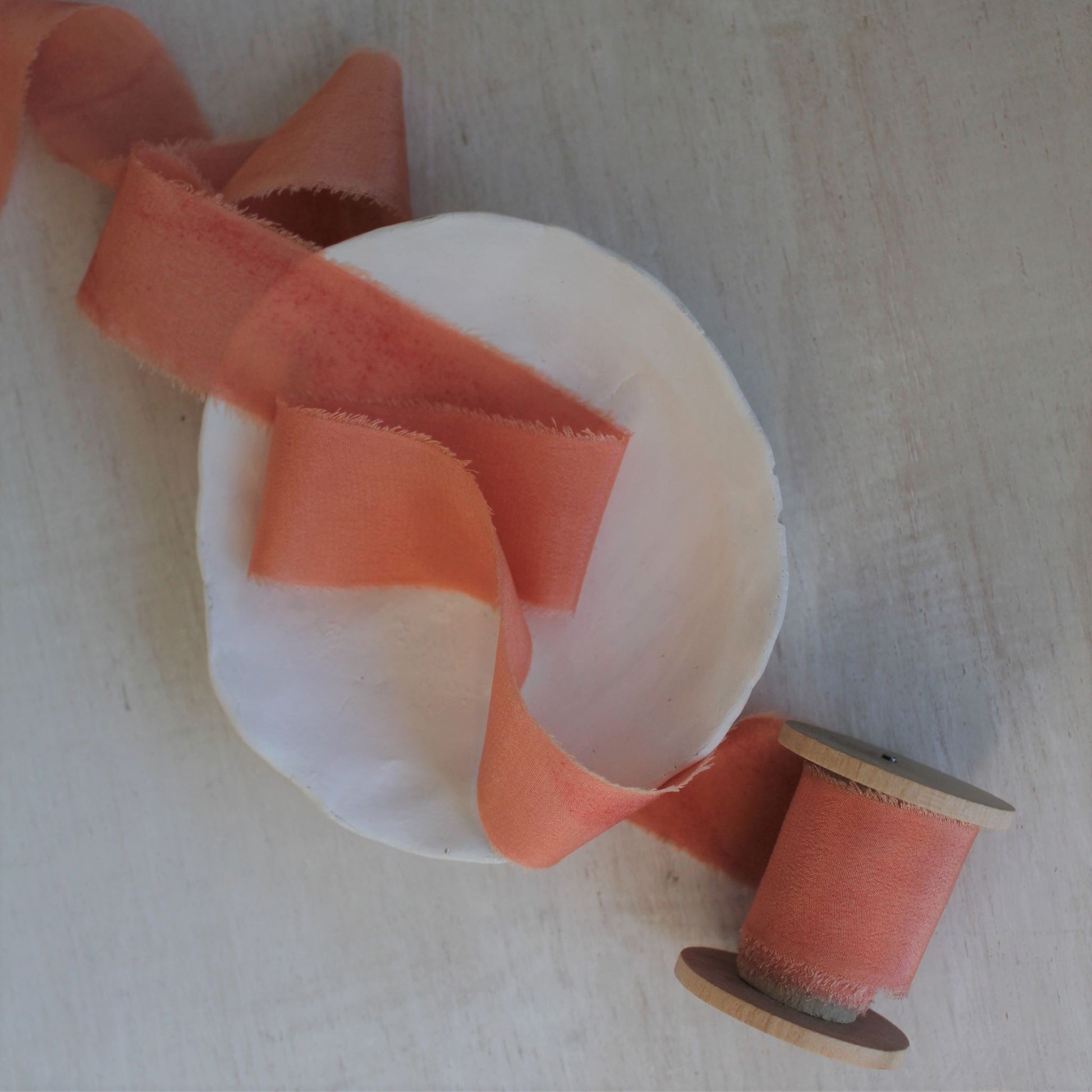 andmade Canadian silk crepe de chine ribbon in a soft coral peach tone, ideal for weddings and special events.