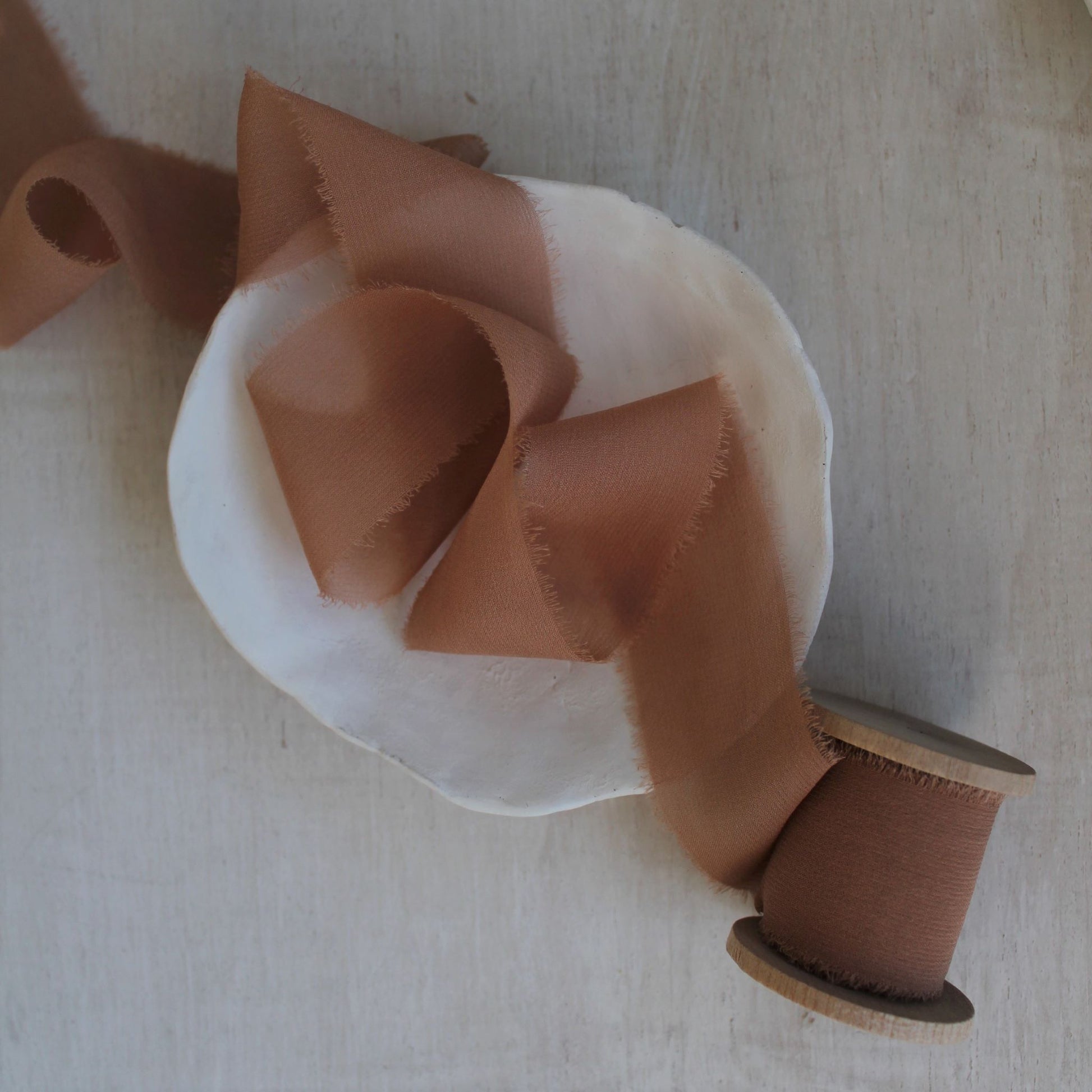 Hand-dyed terra cotta chiffon silk ribbon draped in soft folds