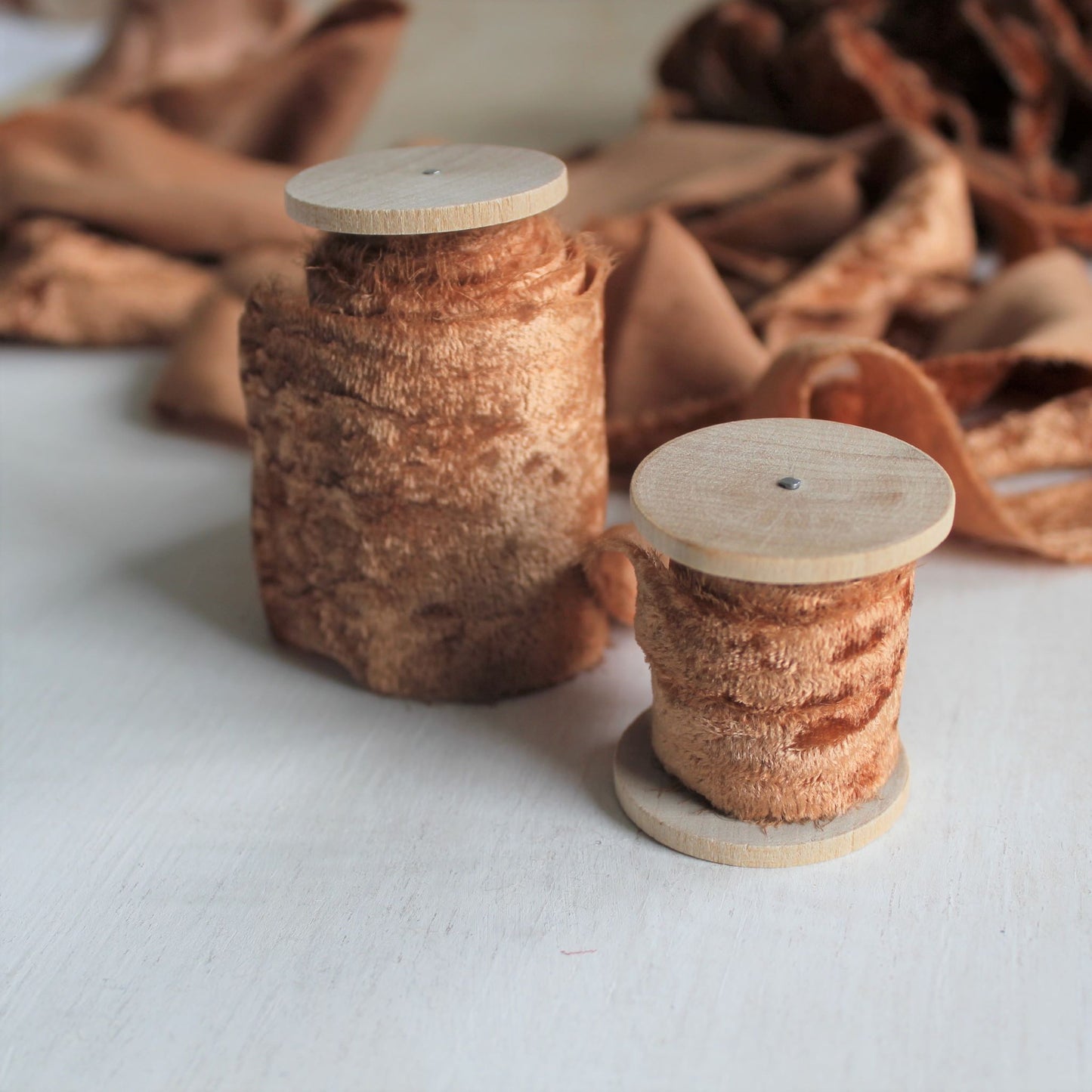 Terra cotta velvet silk ribbon rolled on wooden spools