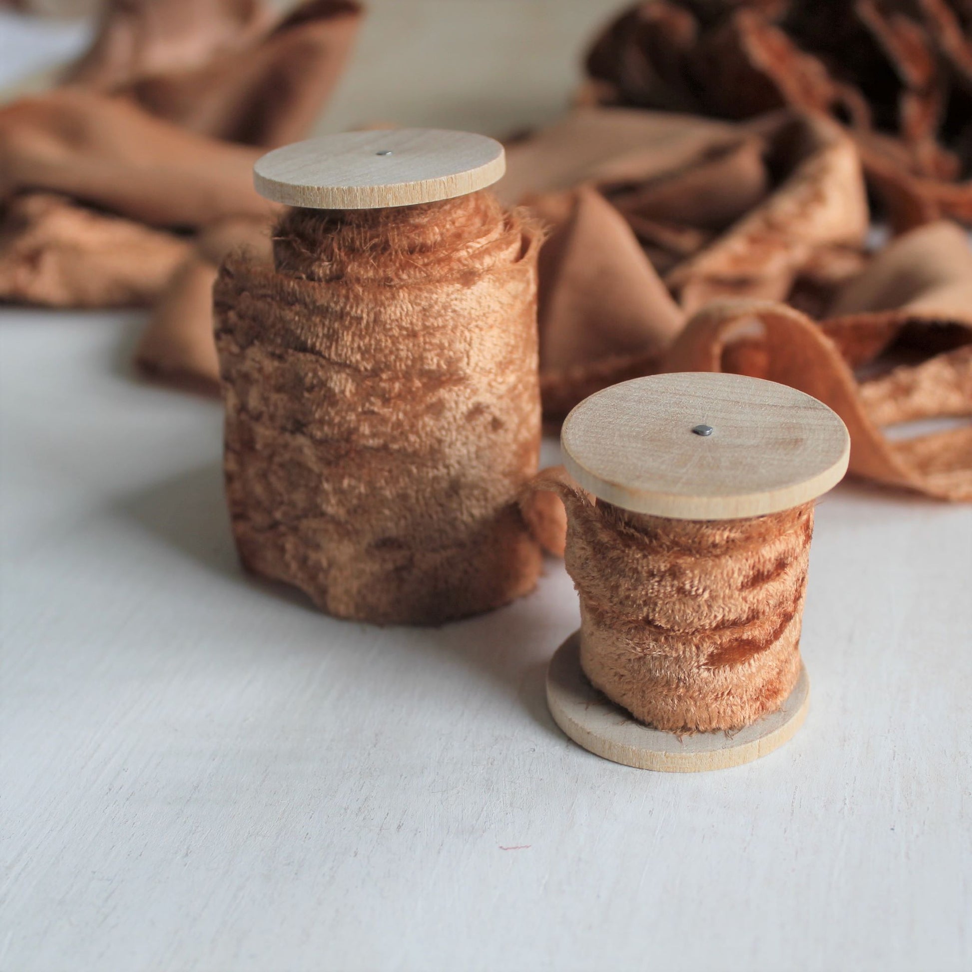 Terra cotta velvet silk ribbon rolled on wooden spools