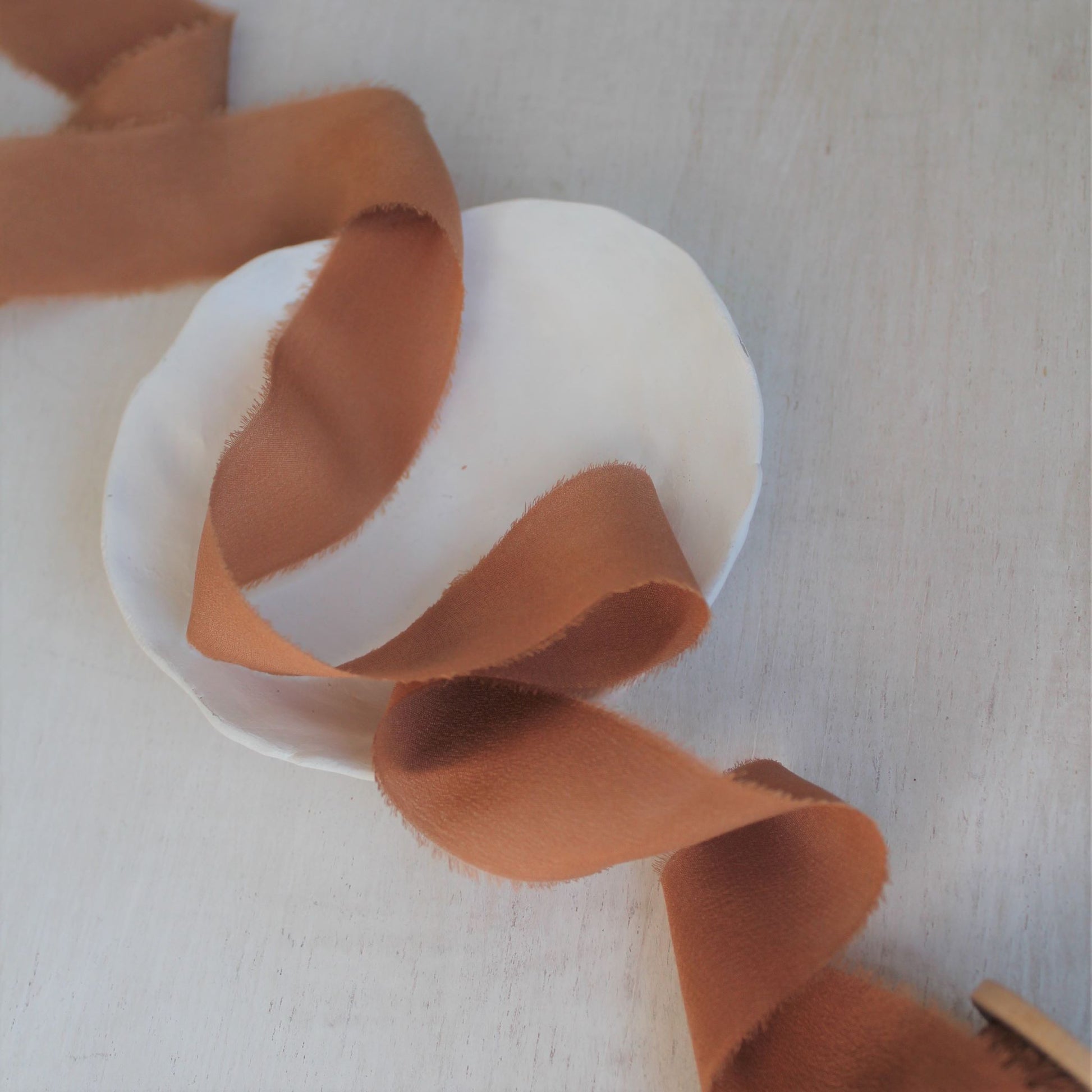 Hand-torn crepe de chine ribbon in warm terra cotta tone
