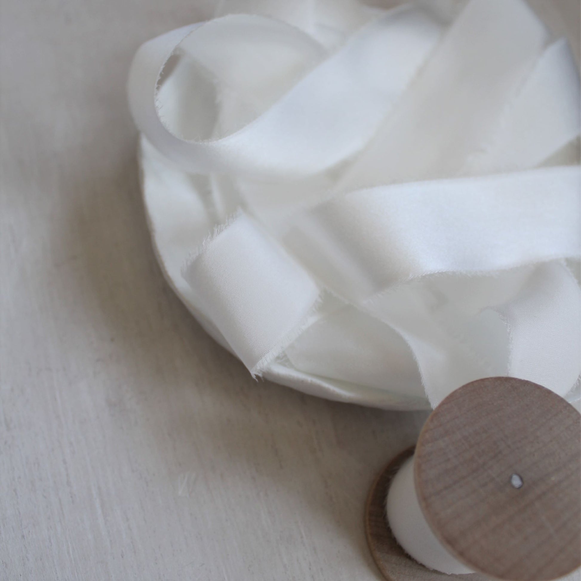 Close-up of the white silk ribbon, highlighting its smooth texture