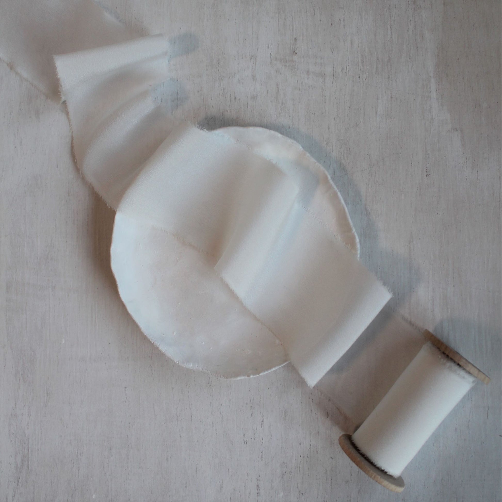 Naturally dyed white silk ribbon in flat lay arrangement