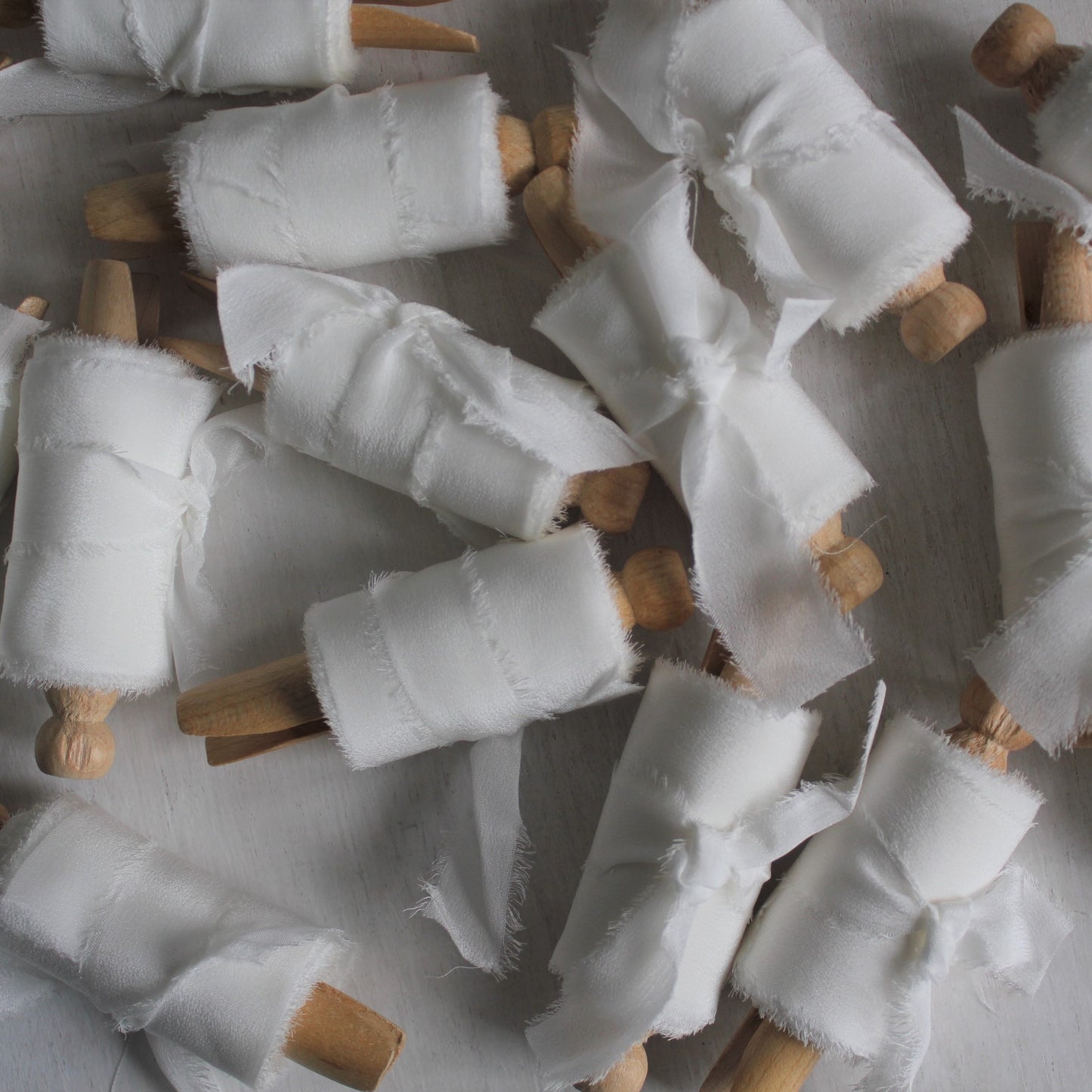 white silk ribbon on wood clothes pegs many silk ribbons